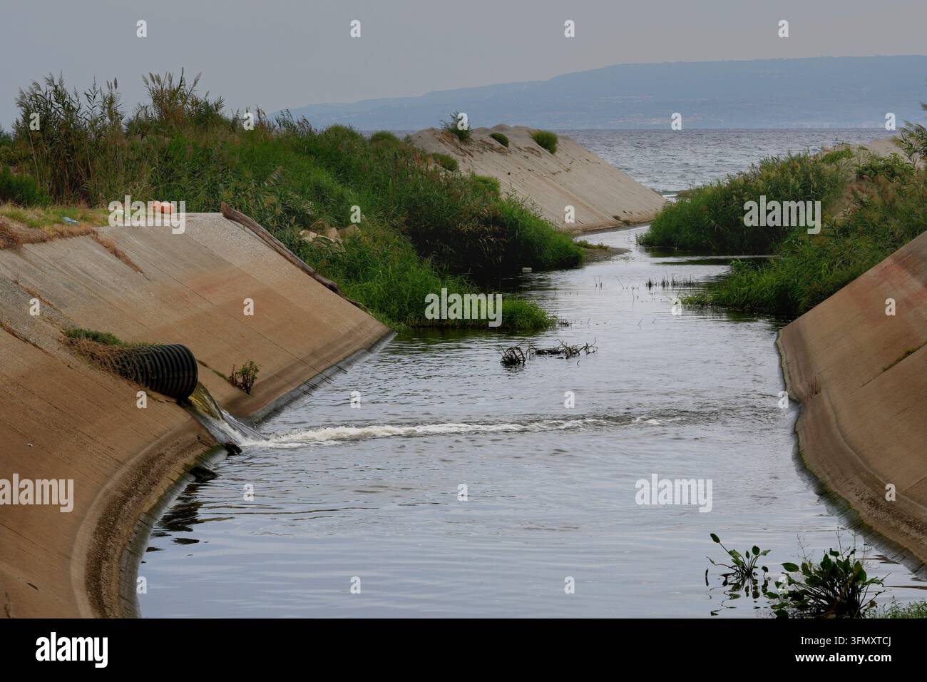 Sversamento di rifiuti industriali tossici da un tubo nel mare. Acque reflue contaminate e scarichi non autorizzati fluiscono direttamente nel mare attraverso un dra Foto Stock