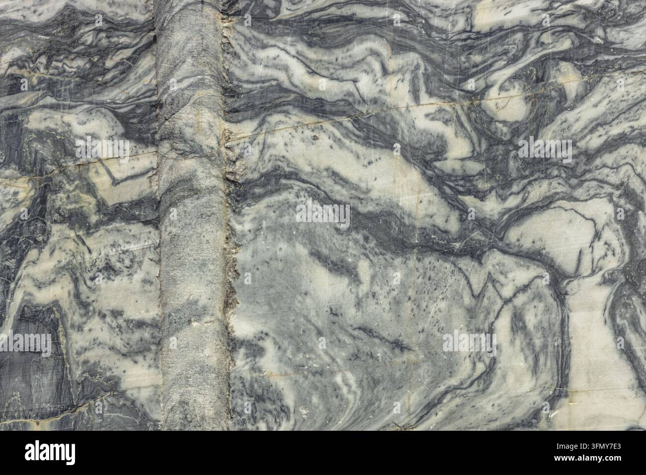 Prima vista di una superficie di marmo con venature grigie e bianche. Pietra naturale strutturata con motivi fluenti. Ideale per sfondi, architettura o progetti di design Foto Stock