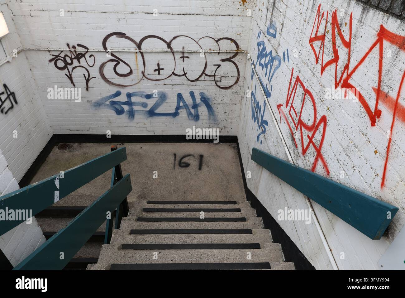 Scalinata in cemento ricoperta di graffiti all'interno di un edificio urbano. Foto Stock