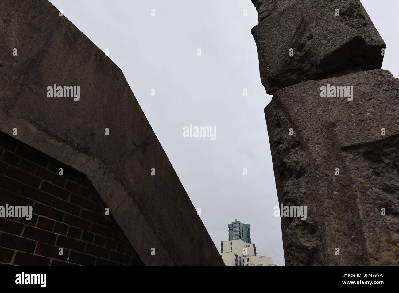Forme angolari in cemento viste dal basso in una struttura urbana brutalista. Foto Stock