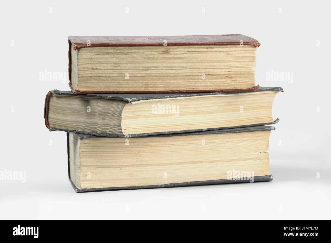 Pile di tre libri vintage con pagine e copertine consumate, che rappresentano l'apprendimento tradizionale, la saggezza e la ricerca d'archivio Foto Stock