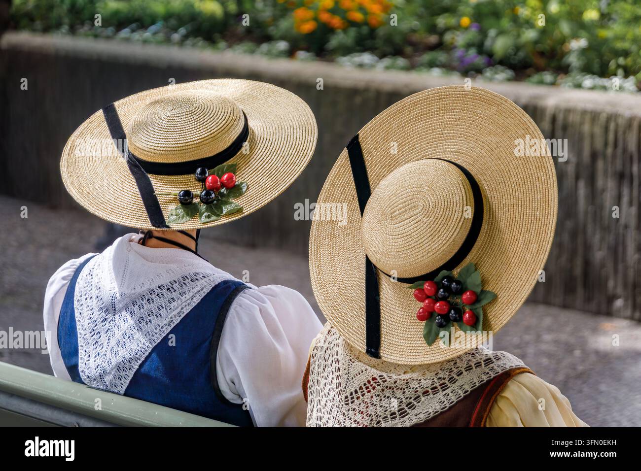 Donne indossano costumi folkloristici regionali tradizionali con cappelli di paglia tessuti elaborati durante la celebrazione del Festival del Costume Nazionale Svizzero a Zurigo, Svizzera Foto Stock