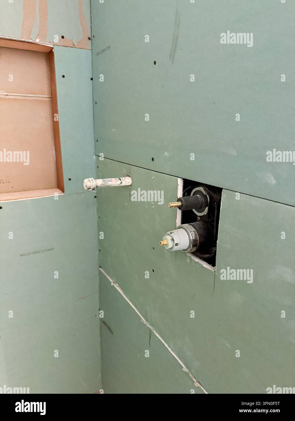 Valvola della doccia esposta e sostituita da un idraulico durante una ristrutturazione della casa Foto Stock