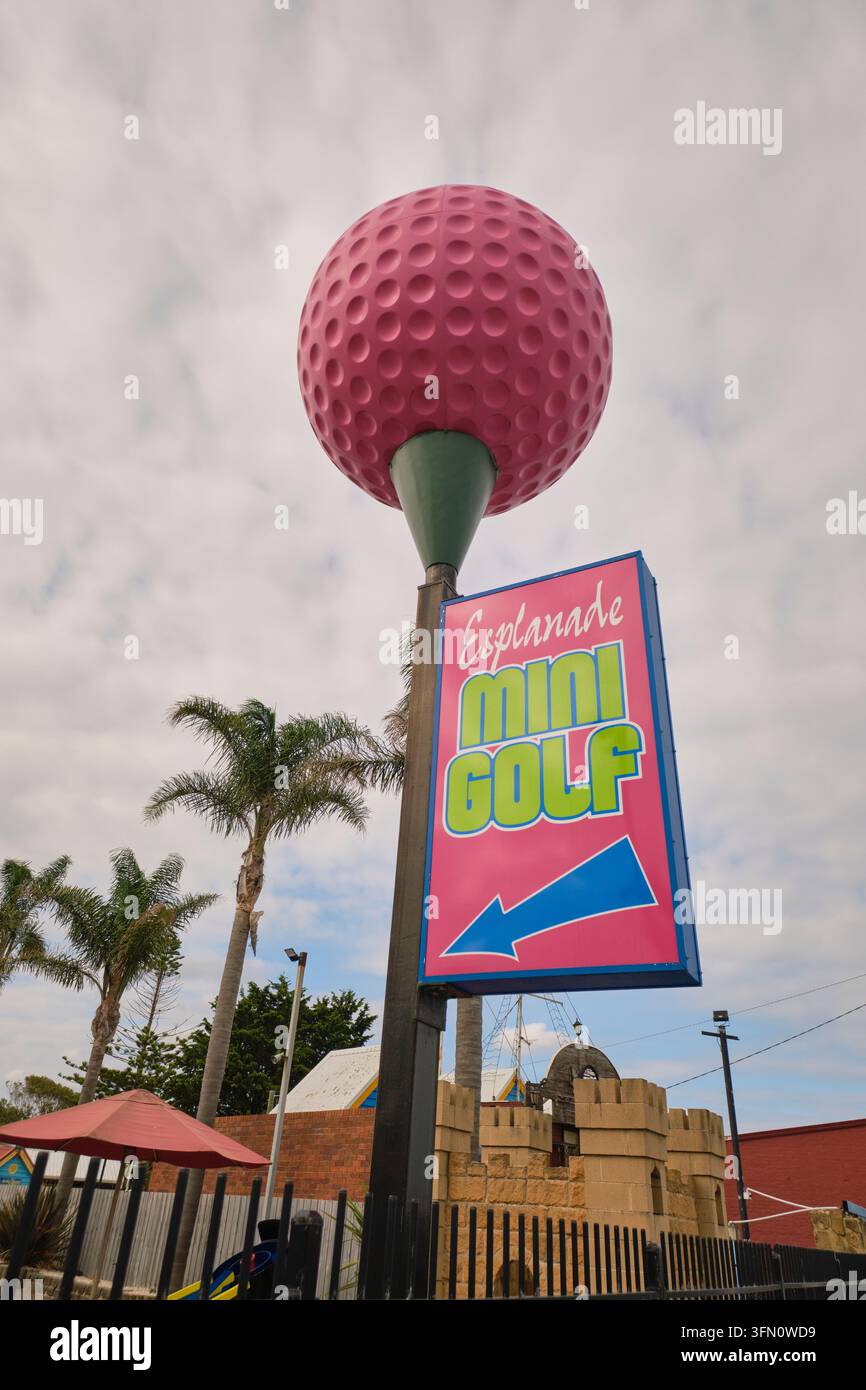 Una grande cosa, una palla da golf gigante di plastica rosa, parte di un cartello per il centro ricreativo Esplanade Mini Golf. A Lakes Entrance, Victoria, Australia. Foto Stock