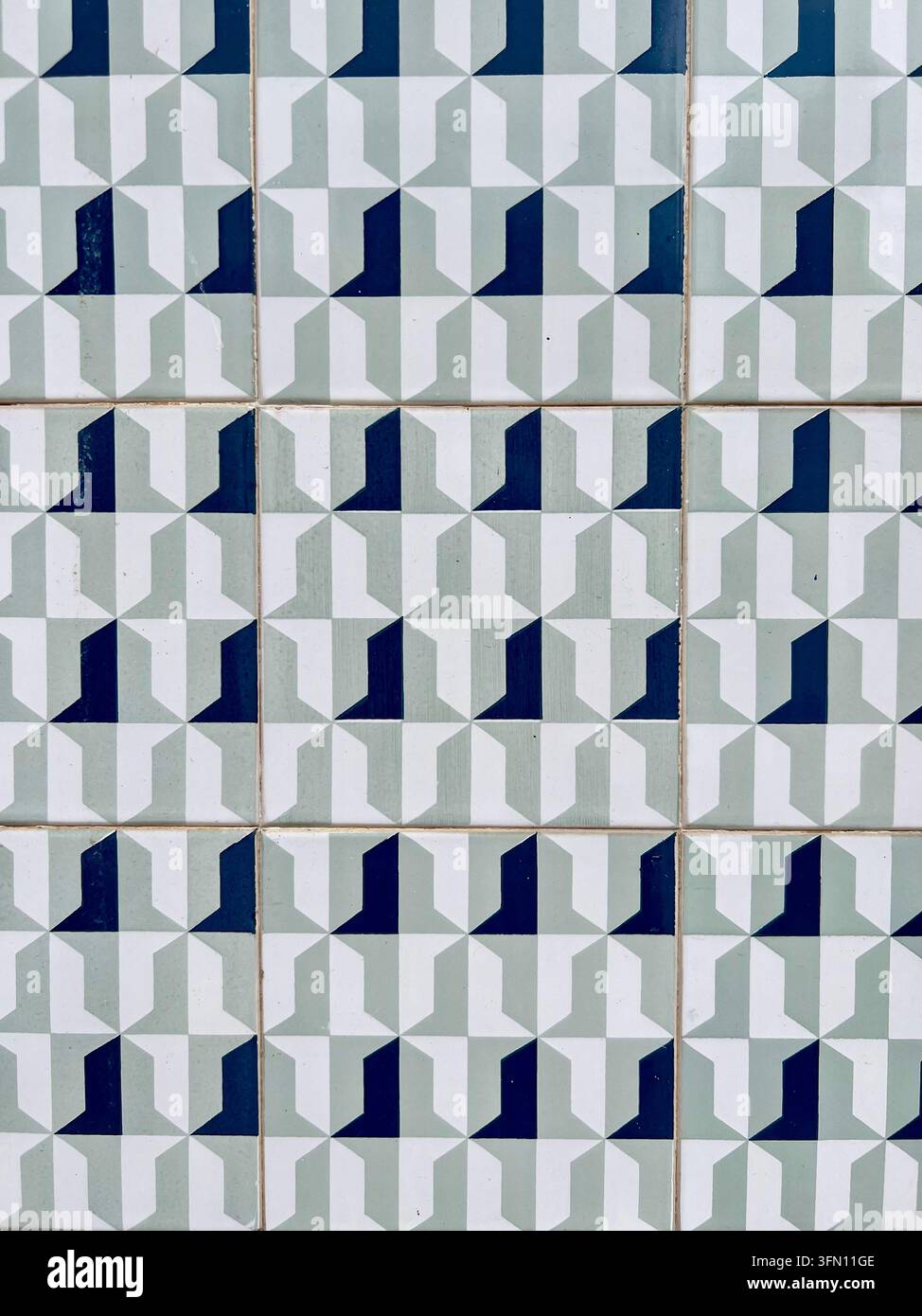 Muro di piastrelle azulejo portoghesi con un motivo geometrico ripetitivo in verde salvia, bianco e blu navy, Portogallo - Immagine stock catturata con smartphone