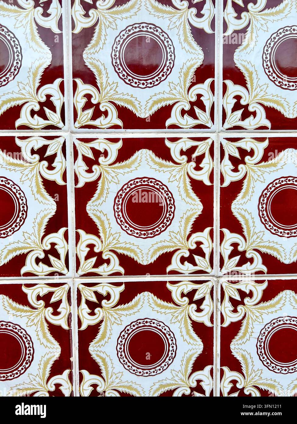Prima di una parete di piastrelle azulejo portoghesi con un motivo floreale bordeaux, bianco e oro, Portogallo - Immagine stock catturata con smartphone