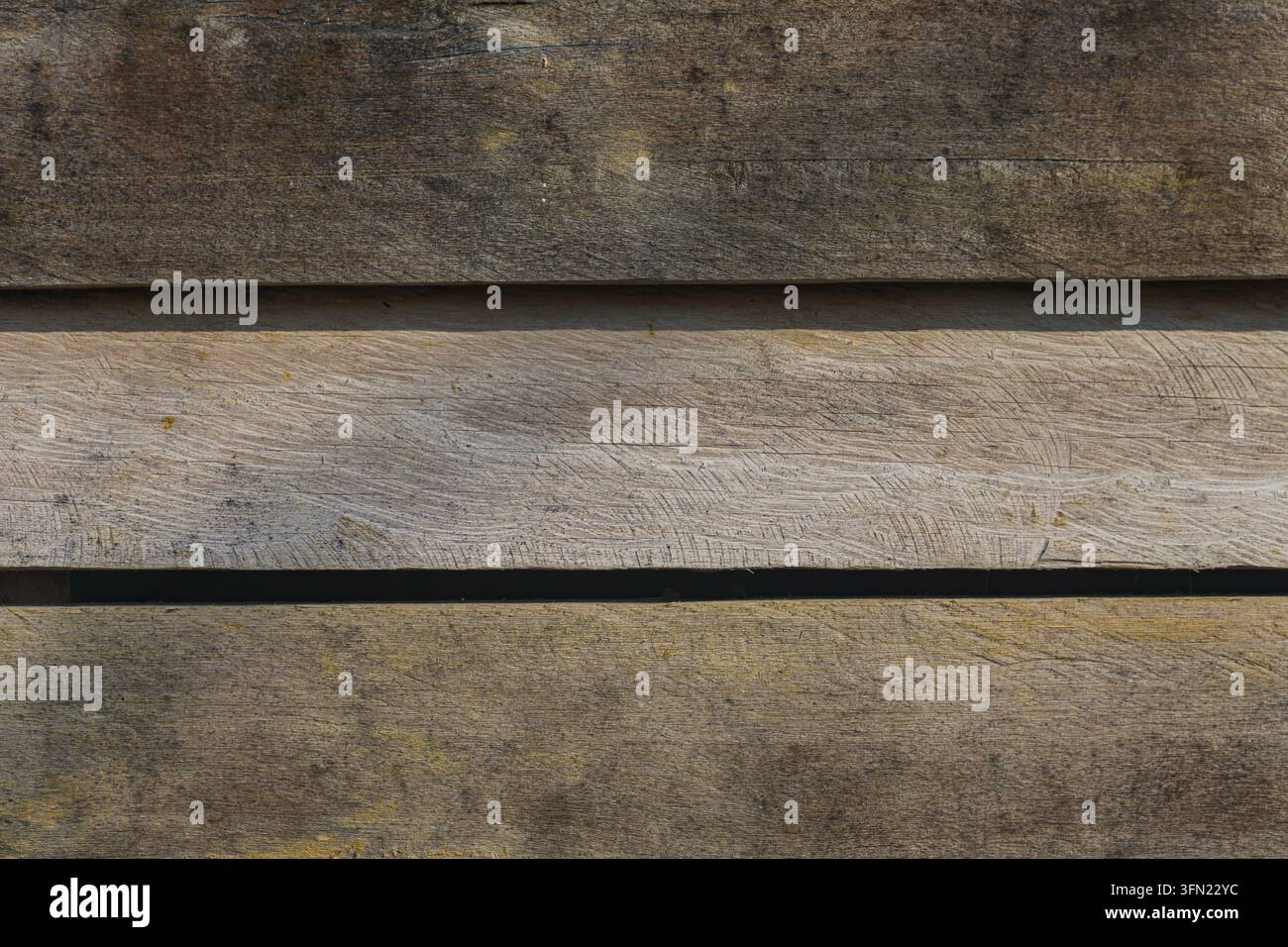 Parete in pannelli di legno consumati di un edificio con assi orizzontali, segni di sega e spazio tra le assi, inquadratura totale Foto Stock