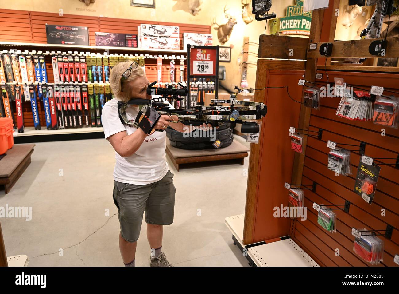 Signora che prova una balestra presso il negozio Outdoor World Bass Pro ad Atlantic City, nel New Jersey. Foto Stock
