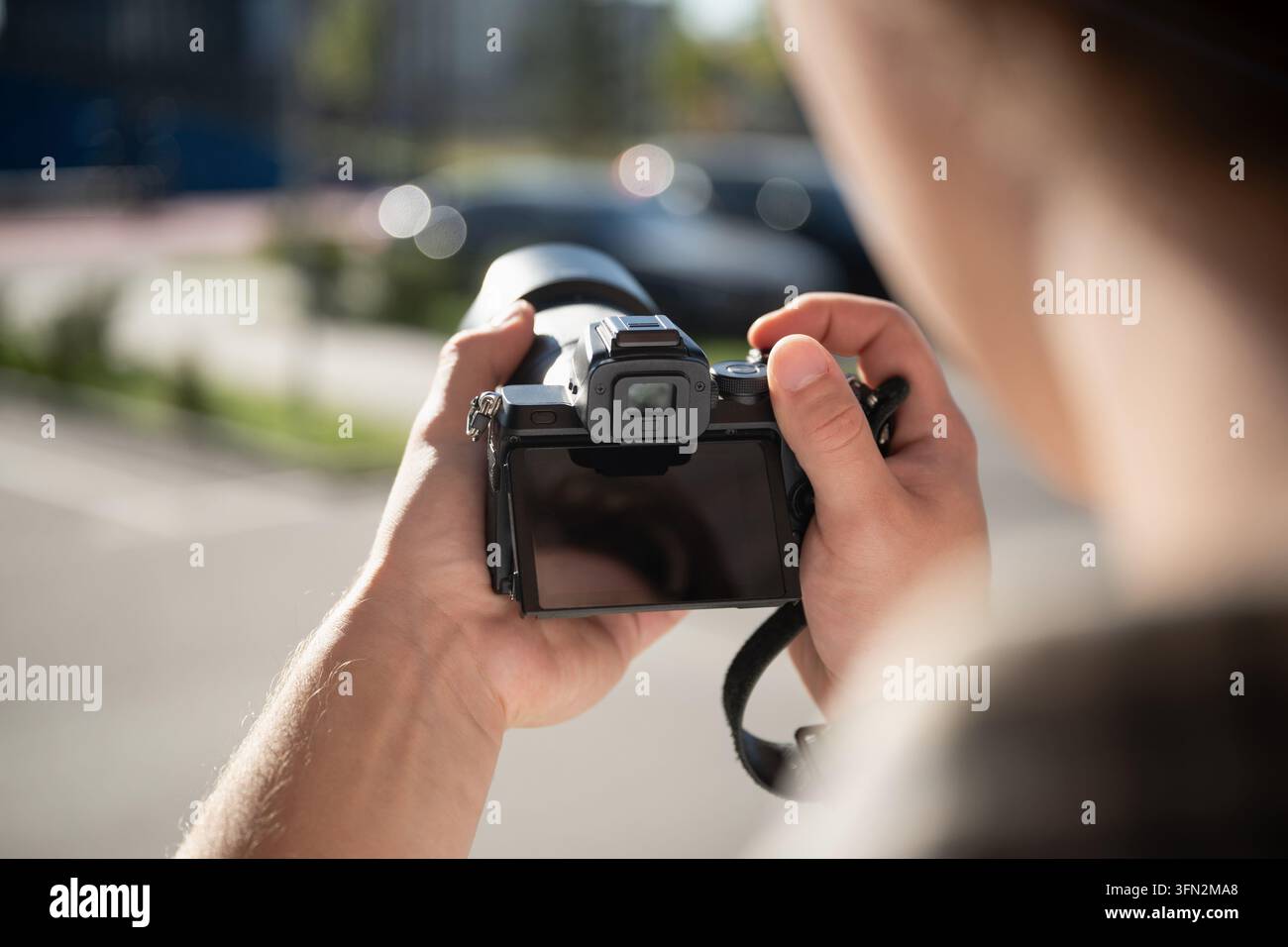 Giovane fotografo che impara la fotografia con una fotocamera digitale all'aperto Foto Stock