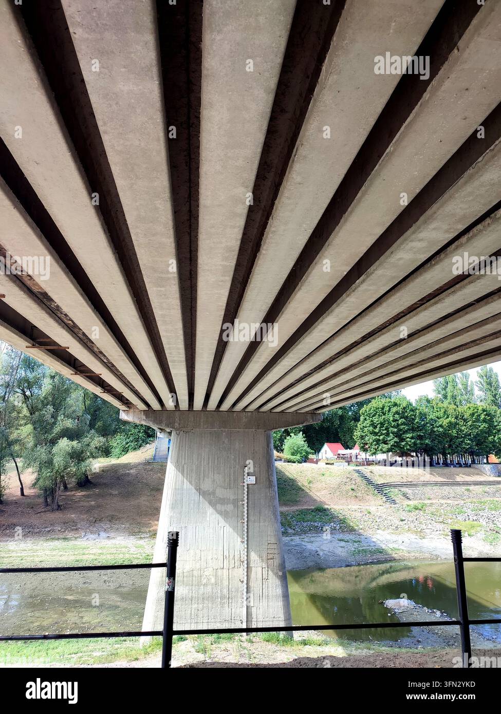 Vista da sotto un ponte di cemento sul fiume Sugovica a Baja, Ungheria - Immagine stock catturata con smartphone