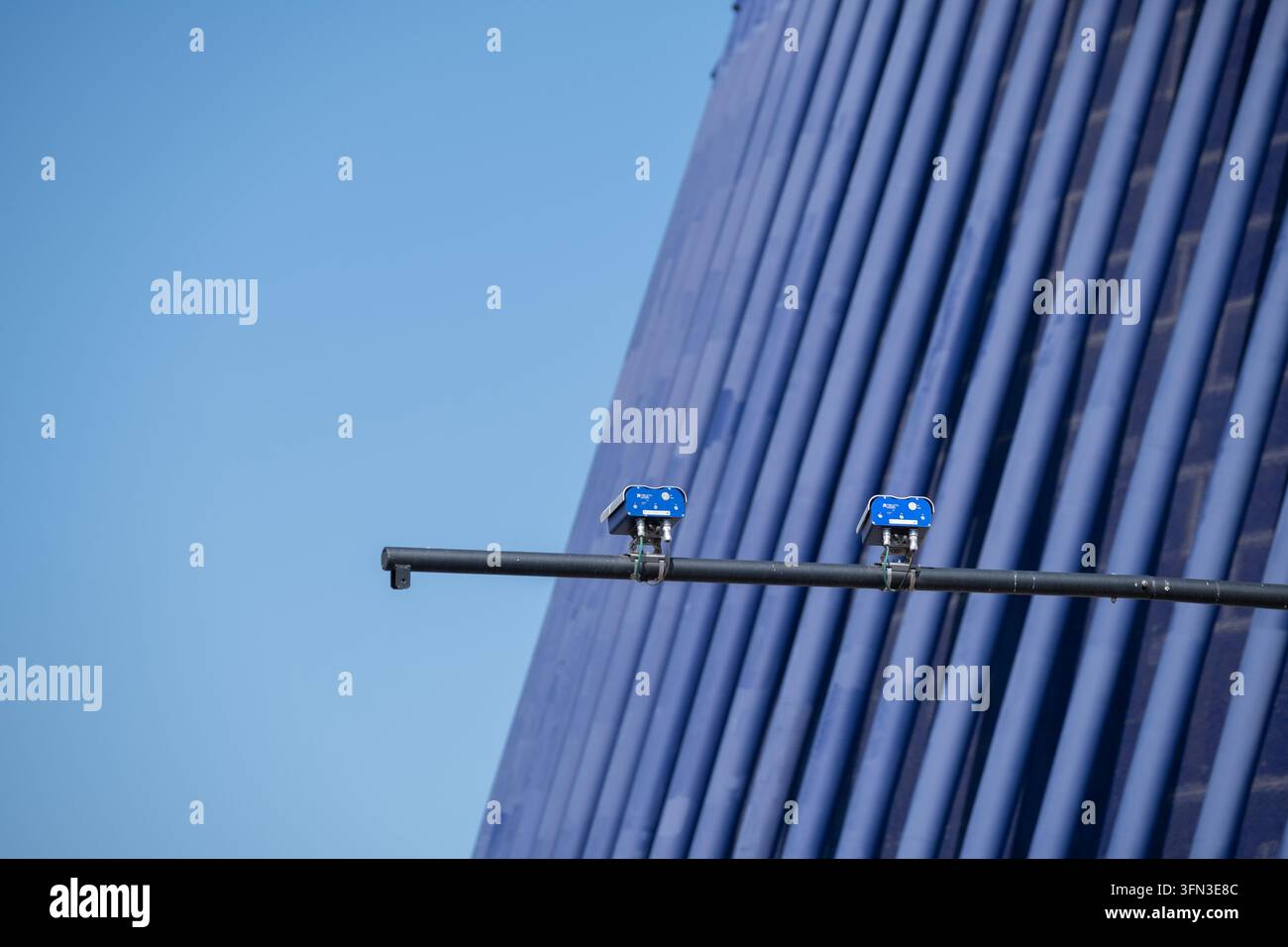 Telecamere di sicurezza montate su un palo con uno sfondo di edificio moderno Foto Stock