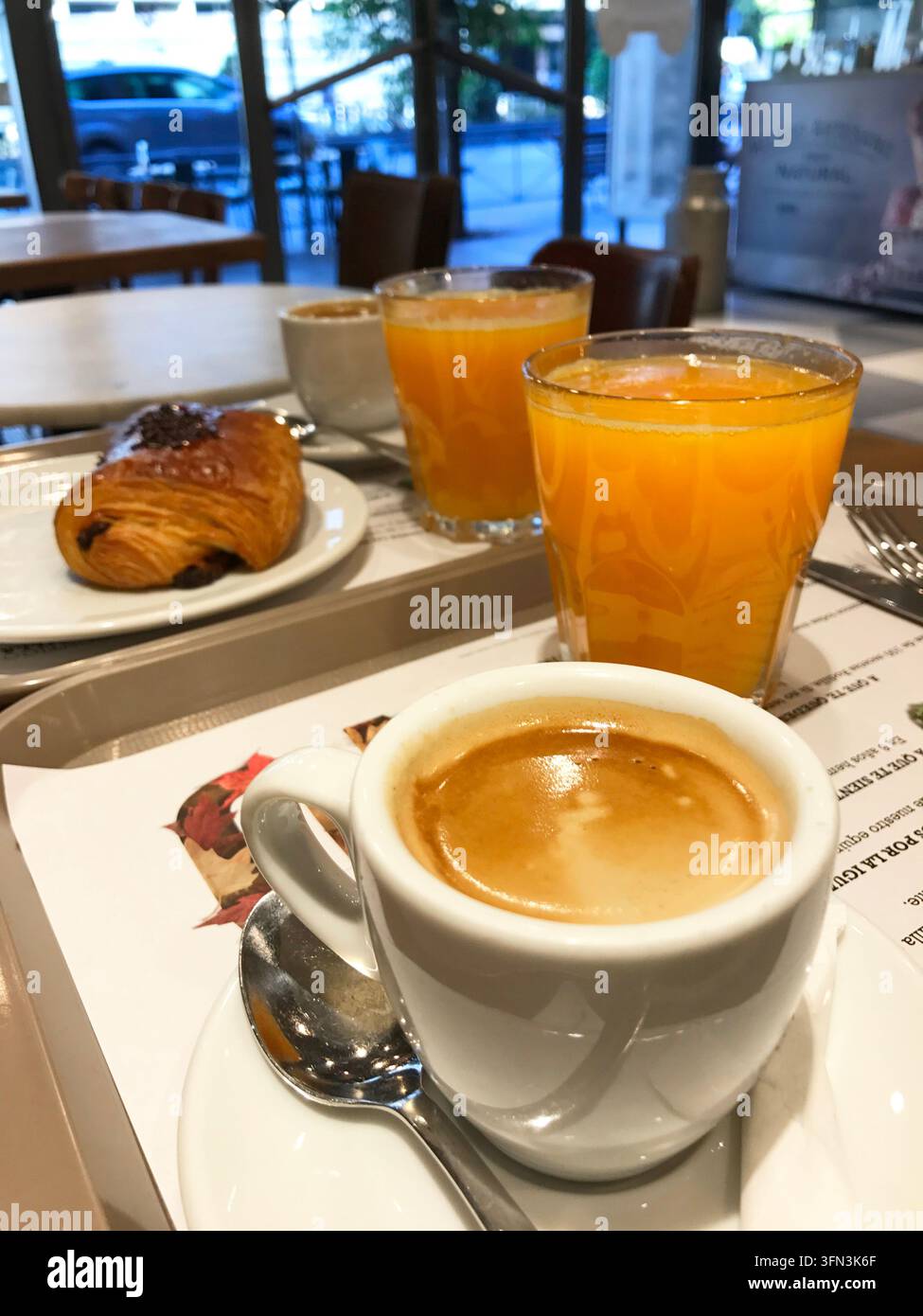 Succhi d'arancia, tazze di caffè e napolitana in una caffetteria. Madrid, Spagna. Foto Stock