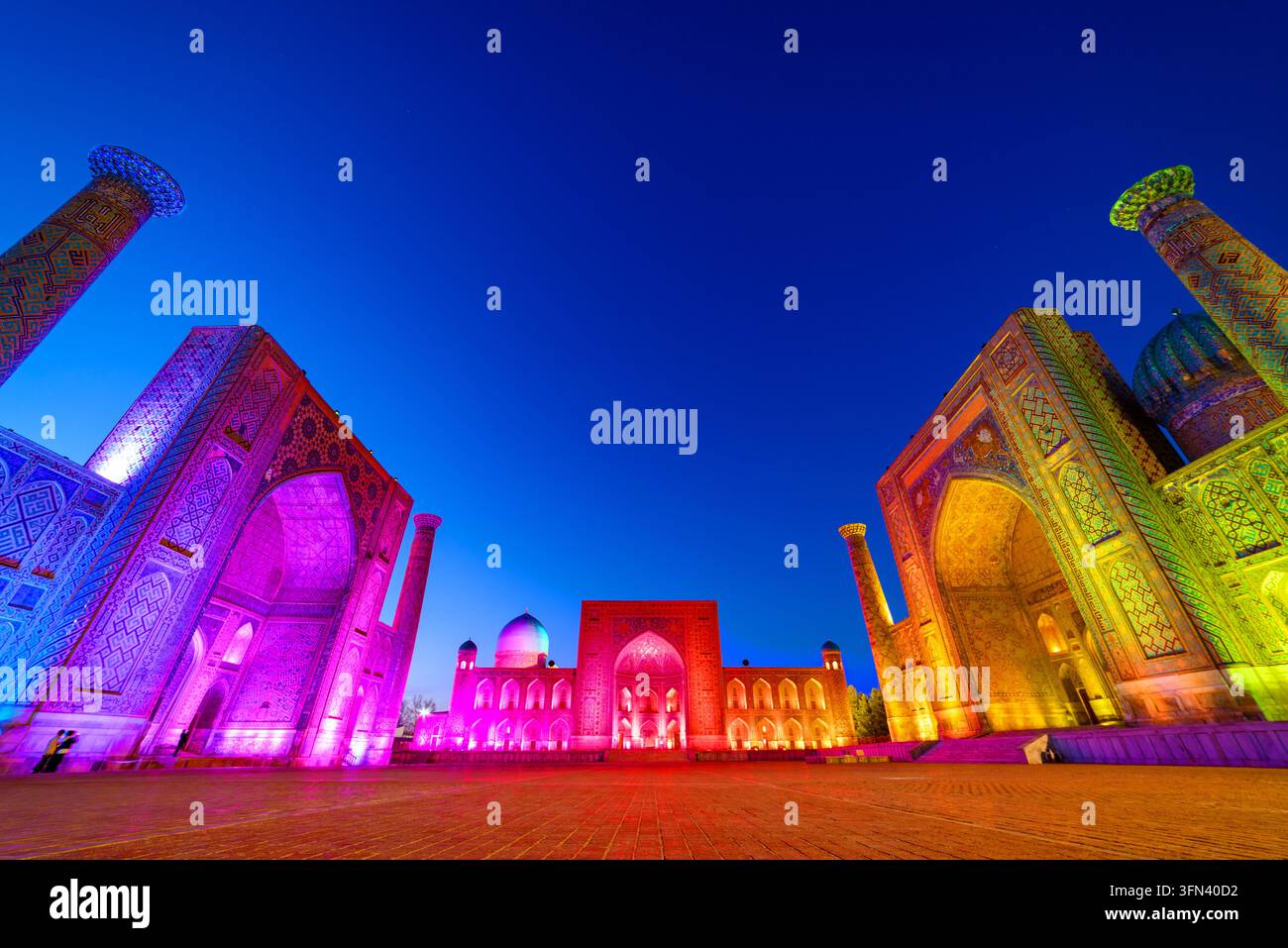 La piazza del Registan e le sue tre madrasse (da sinistra a destra): la madrasa di Ulugh Beg, la madrasa Tilakari e la madrasa Sherdar di notte Foto Stock