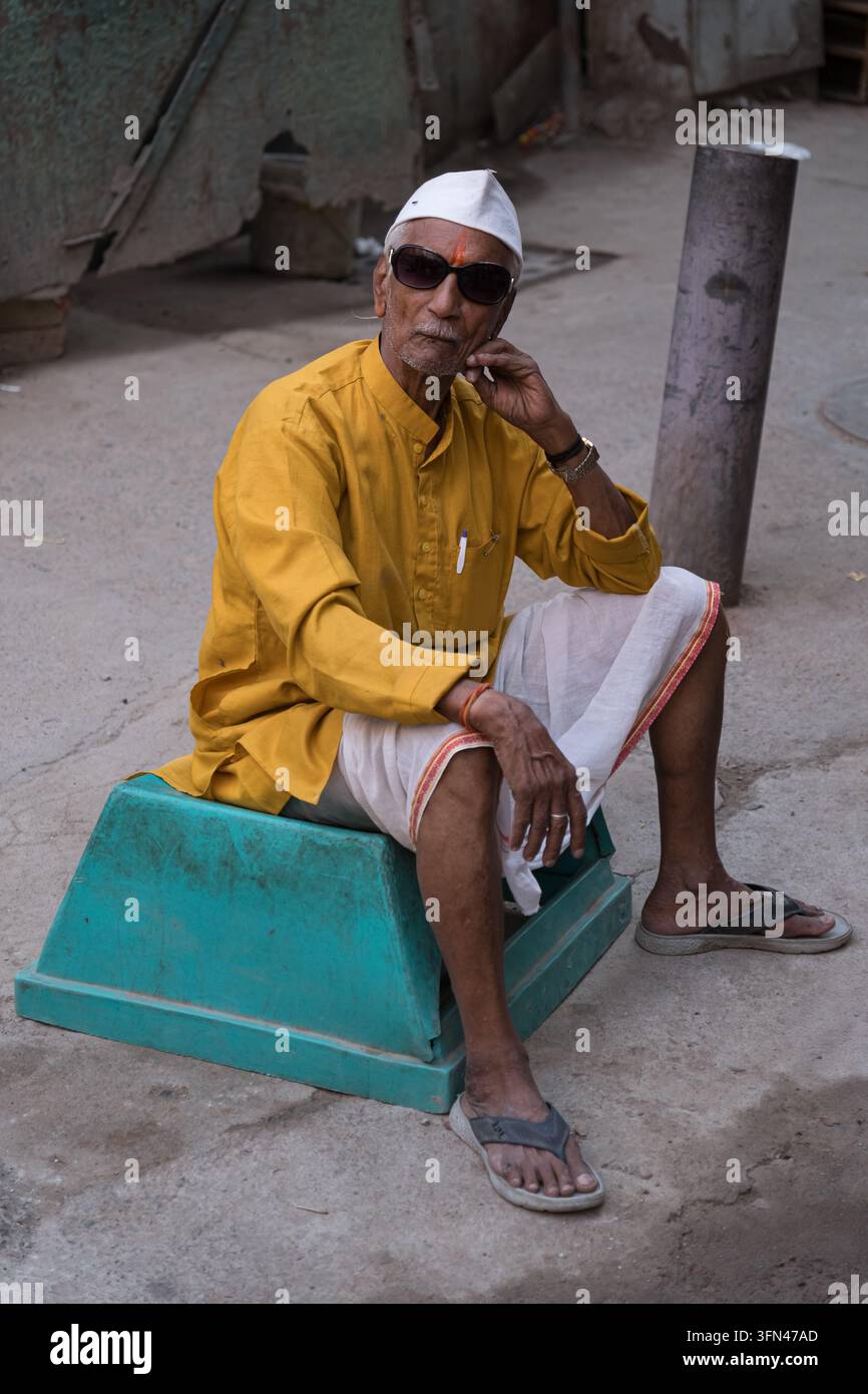 Anziano uomo indiano con un cappello bianco tradizionale di Gandhi, che riflette la cultura quotidiana indiana e l'abbigliamento tradizionale. Foto Stock
