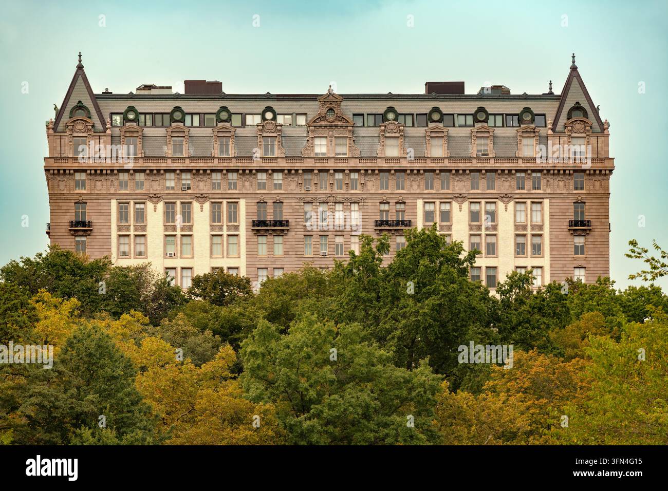 Il palazzo residenziale The Langham al 135 Central Park West, New York City, visto dal Central Park, con alberi frondosi e una facciata in pietra ornata. Foto Stock