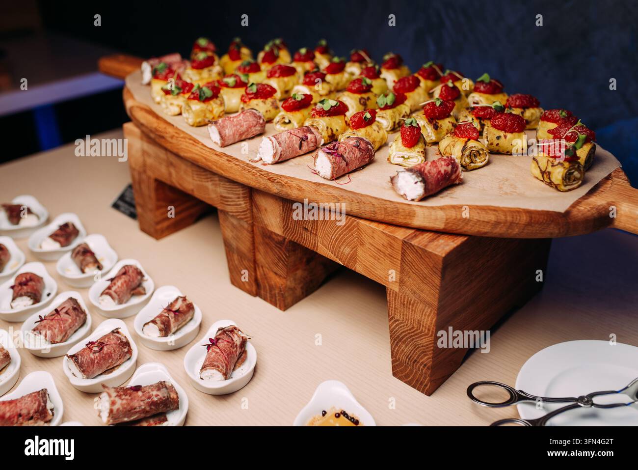 Antipasti di catering gourmet disposti su un tagliere di legno Foto Stock
