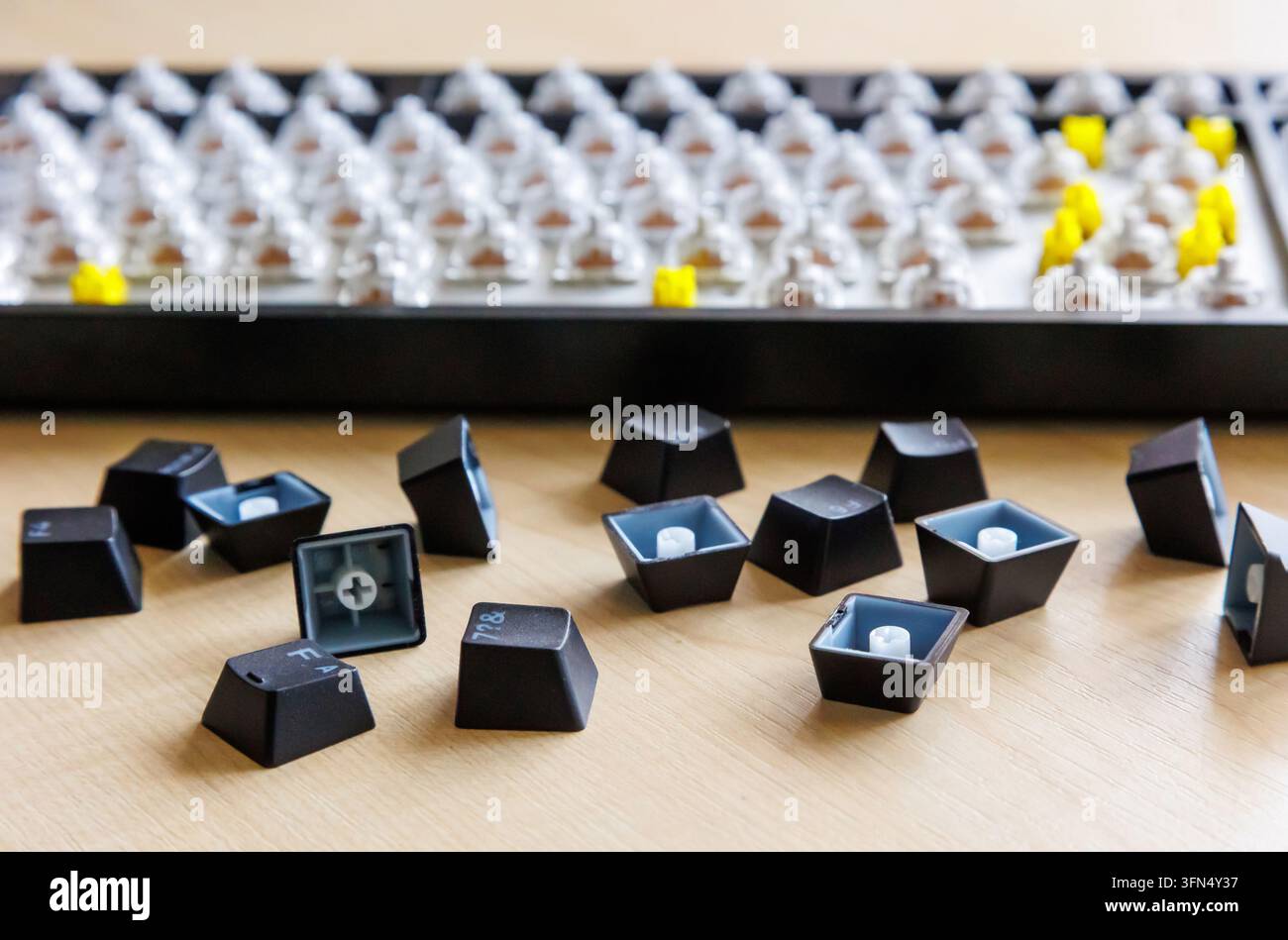 Tastenkappen rimosse, parti di tastiera sulla scrivania, tastiera di computer smontata sullo sfondo, tasti di ricambio, componenti hardware, riparazione, manutenzione. Foto Stock