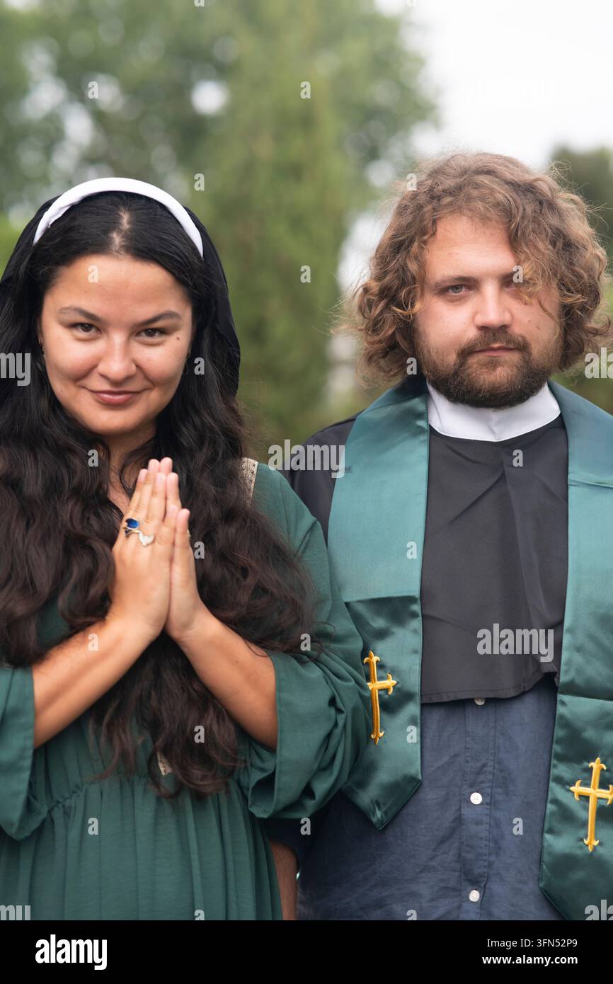 Due ospiti di nozze posano in abiti cerimoniali Foto Stock