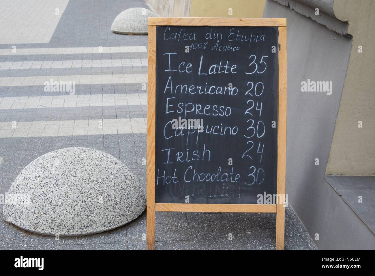 Menu del caffè scritto a mano sul marciapiede che pubblicizza l'arabica etiope e bevande calde e fredde - Chișinău, Moldavia - 12 settembre 2026 Foto Stock
