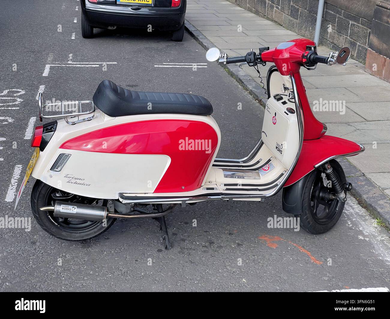 Una Scomadi Turismo Technica 200W, uno scooter moderno in stile retrò con verniciatura rossa e crema, parcheggiato in strada, Edimburgo, Scozia, Regno Unito - Immagine stock catturata con smartphone
