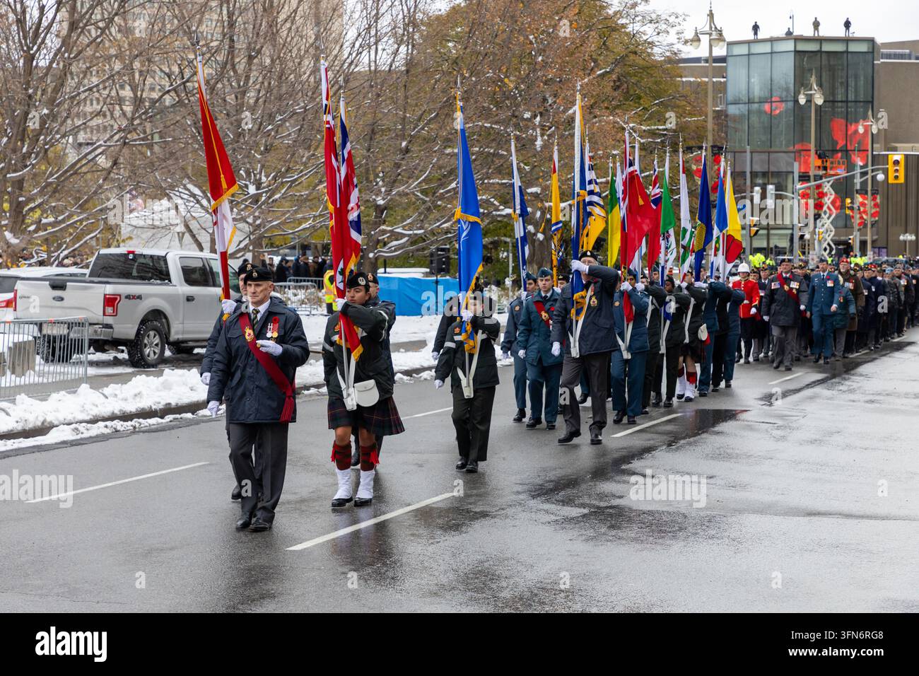 Ottawa, Canada - 11 novembre 2025: Parata del Giorno della Memoria nel centro di Ottawa. Veterani canadesi e portabandiera guidano la processione cerimoniale Foto Stock