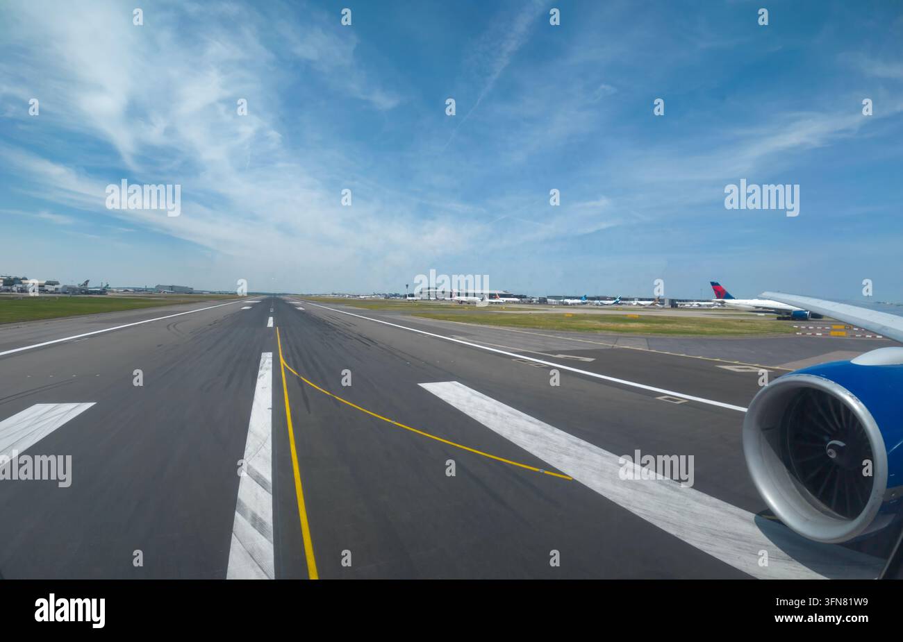 Viaggi e Storia: Vista dell'ala e del motore di un aereo di linea allineato per il decollo sulla pista dell'aeroporto di Londra Heathrow, Inghilterra Foto Stock
