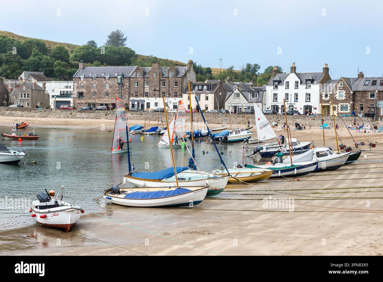 Stonehaven, Scozia, Regno Unito – 17 agosto 2025: dinghy a vela e piccole barche riposano nel porto di Stonehaven mentre gli equipaggi si preparano per una regata di yacht, con il Foto Stock