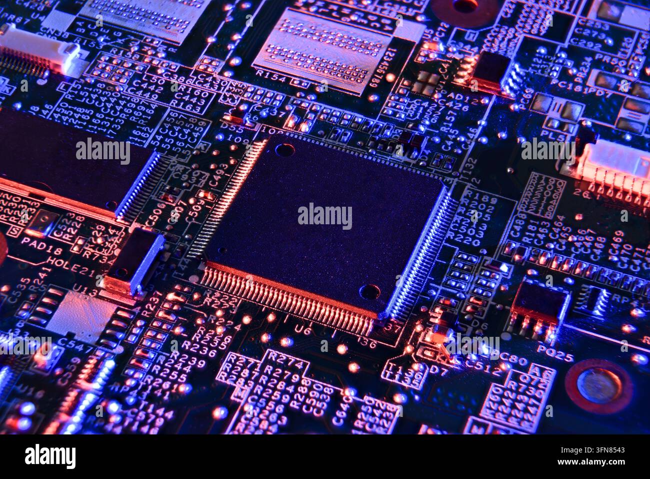 Immagine macro ad alto dettaglio di un microchip circondato da circuiti al neon luminosi, simbolizzanti l'informatica futuristica, la tecnologia IA, la cybersecurity e la digitalizzazione Foto Stock