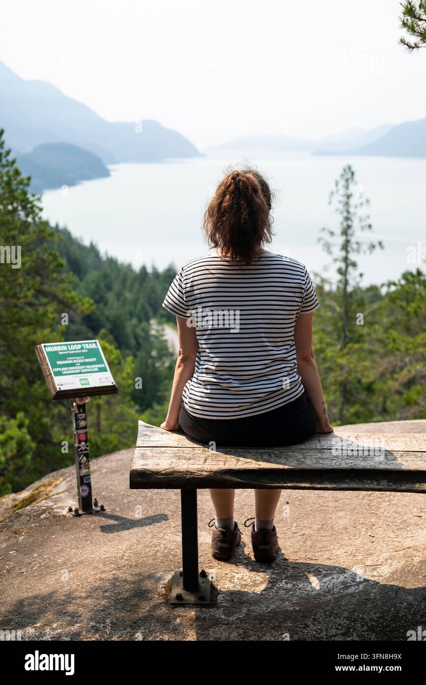 Persona che gode di una splendida vista sulla baia di Squamish dal lago Murrin Foto Stock