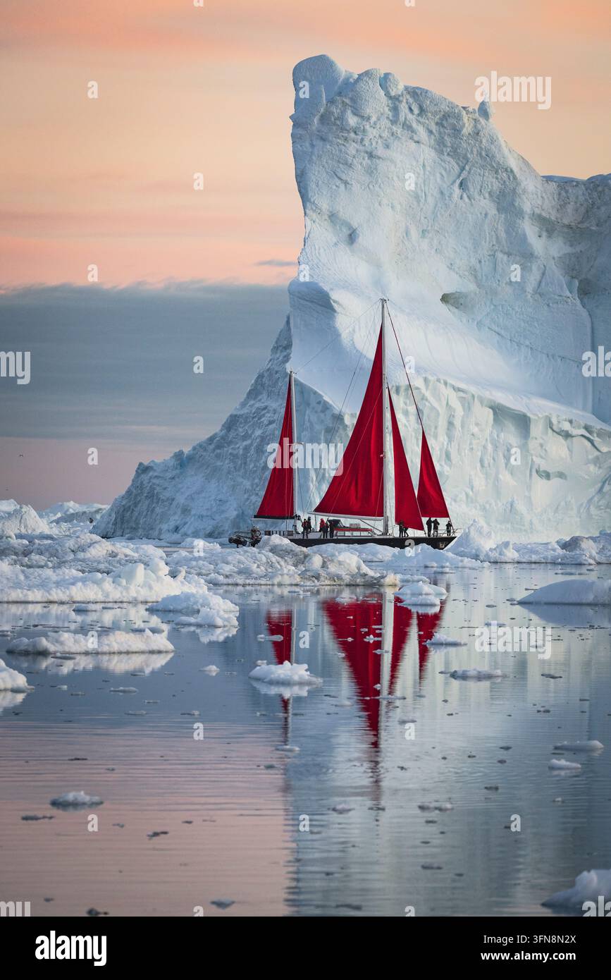 Drammatica barca a vela rossa naviga nelle acque ghiacciate polari Foto Stock