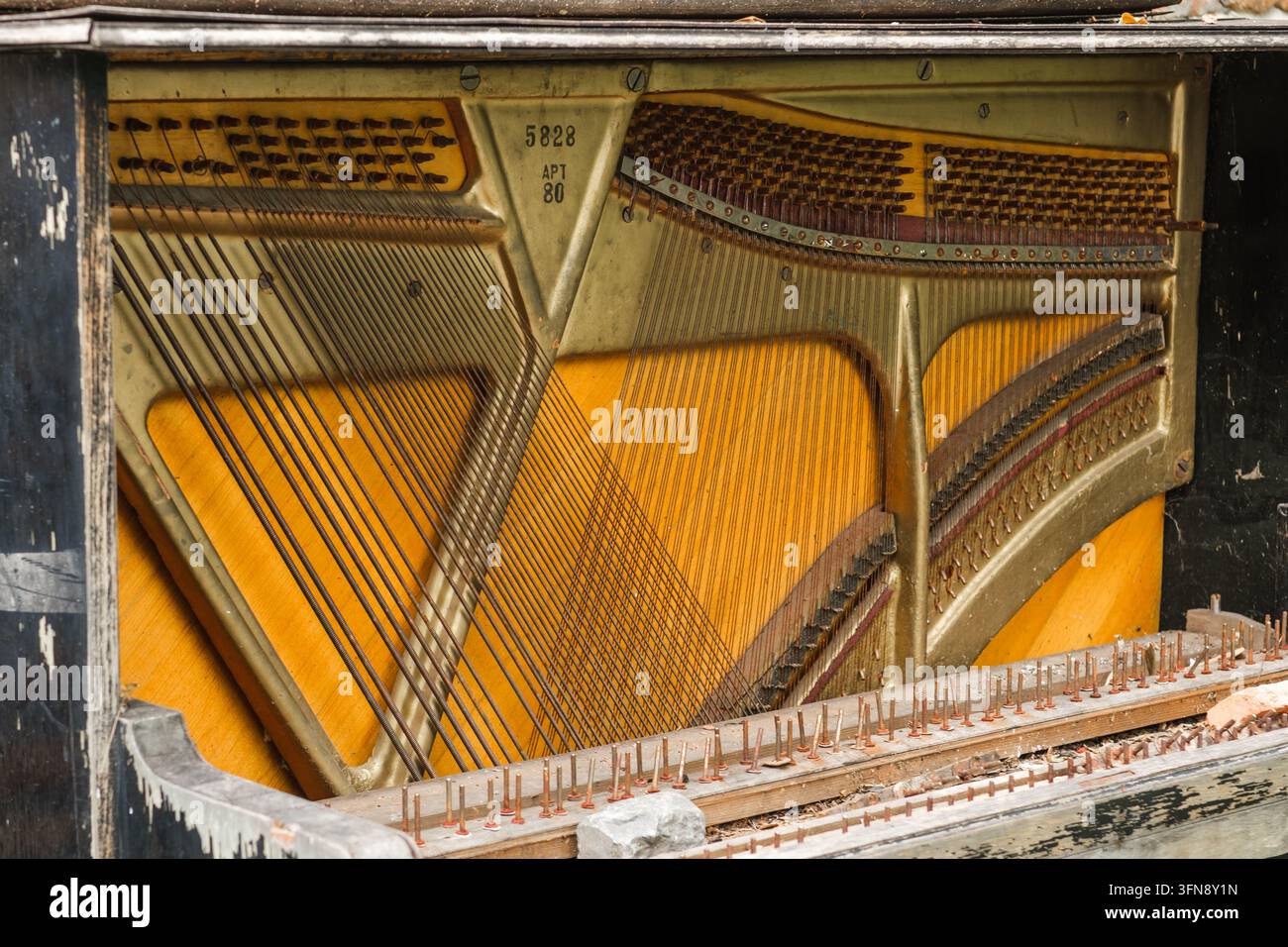 Tbilisi, Georgia - 1 settembre 2026: Un pianoforte verticale aperto rivela corde incrociate, struttura metallica, pioli di accordatura, ammortizzatori e tavola armonica in legno arancione in Foto Stock