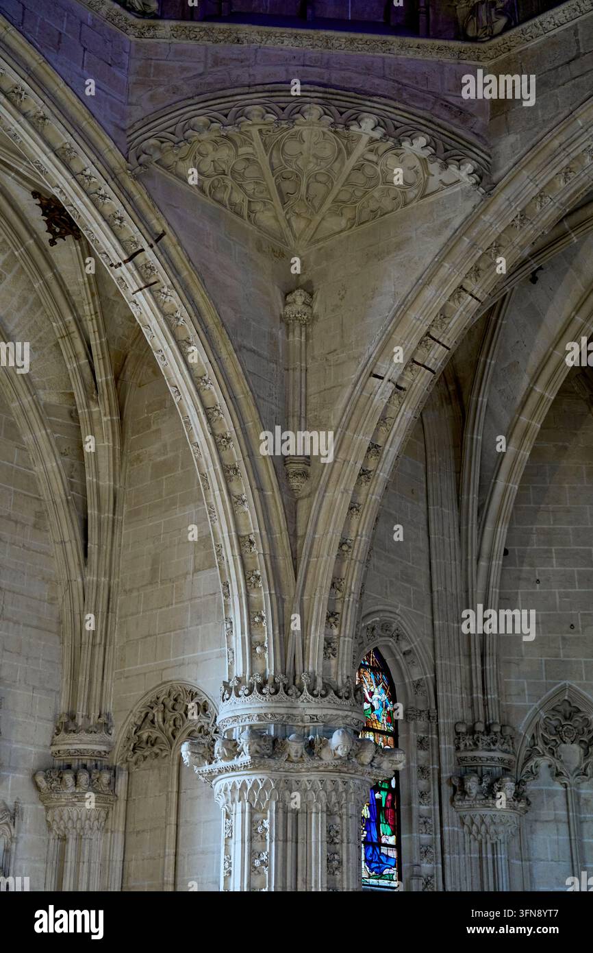 Volte a crociera gotiche che partono da un pilastro scolpito con teste e baldacchini nella chiesa di San Juan de los Reyes, Toledo, Spagna Foto Stock