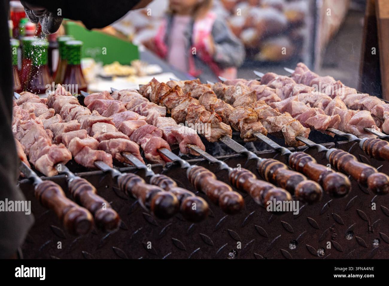 Vista di spiedini di carne speziati che grigliano su una griglia di metallo in un mercato all'aperto a Vilnius, contea di Vilnius, Lituania. Foto Stock