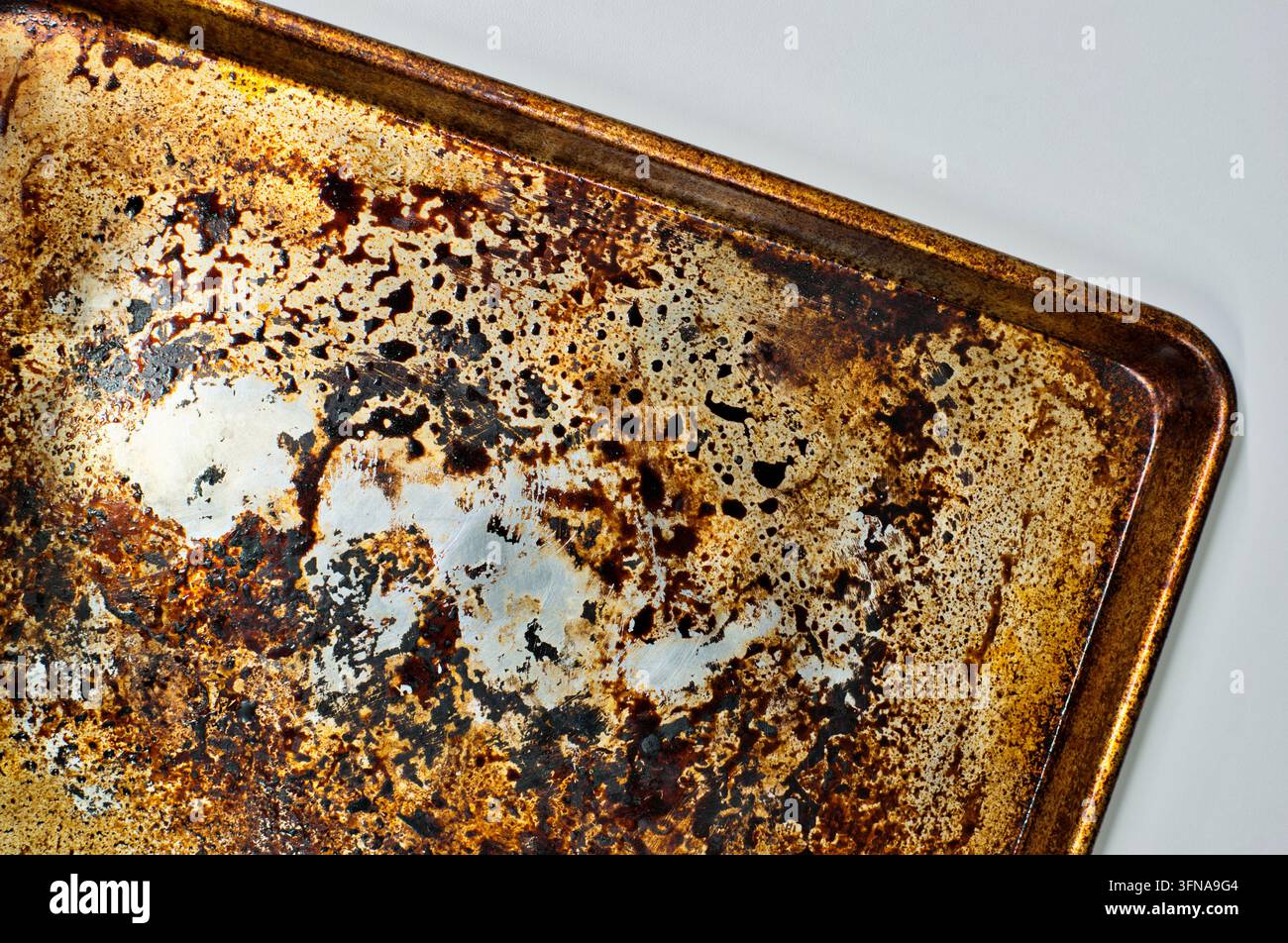 Teglia per biscotti in alluminio sporca e macchiata, concetto di pulizia della teglia da forno. Foto Stock