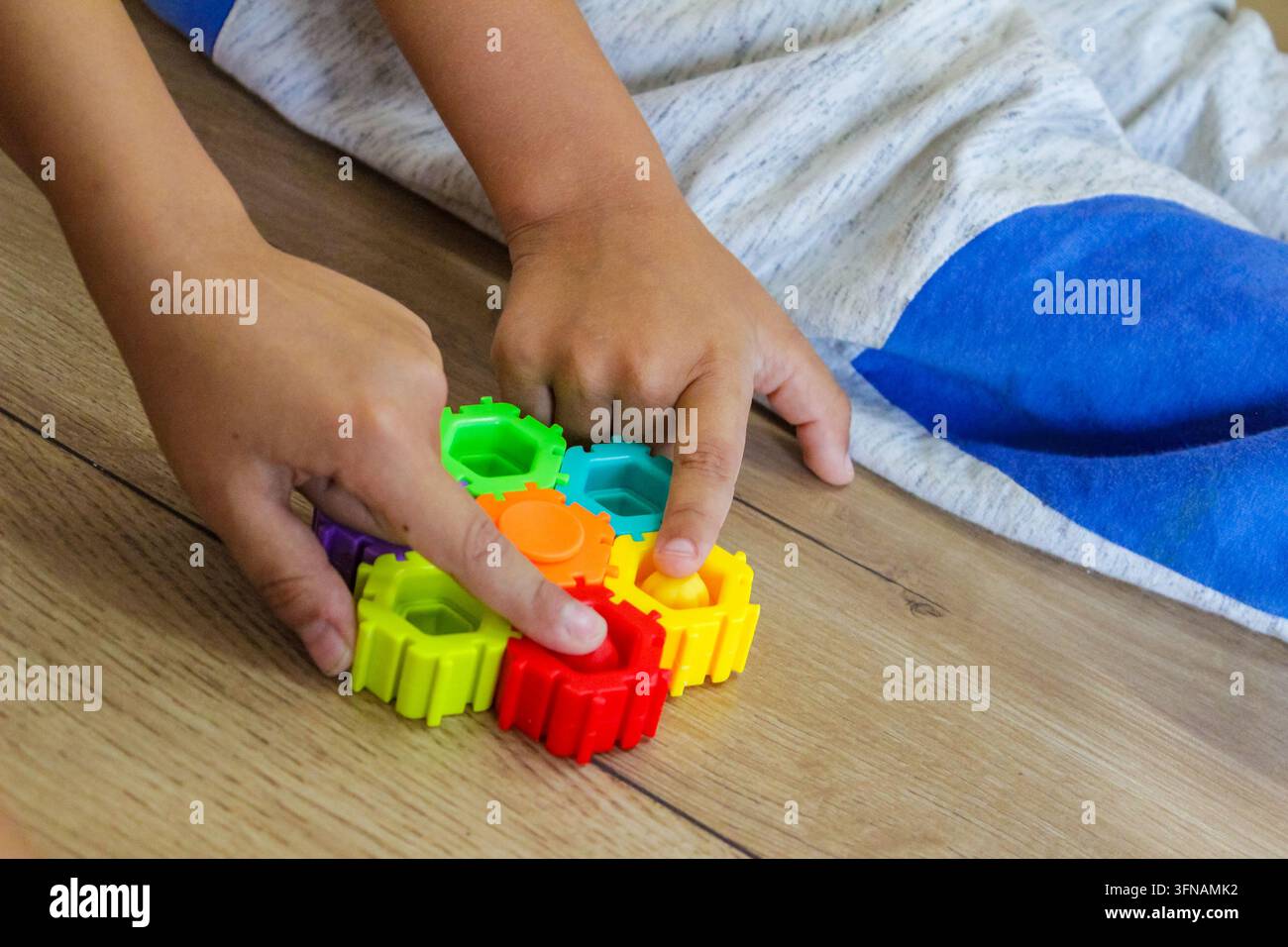 Bambino che assembla un giocattolo educativo colorato, concetto di apprendimento STEM e sviluppo della motricità fine Foto Stock