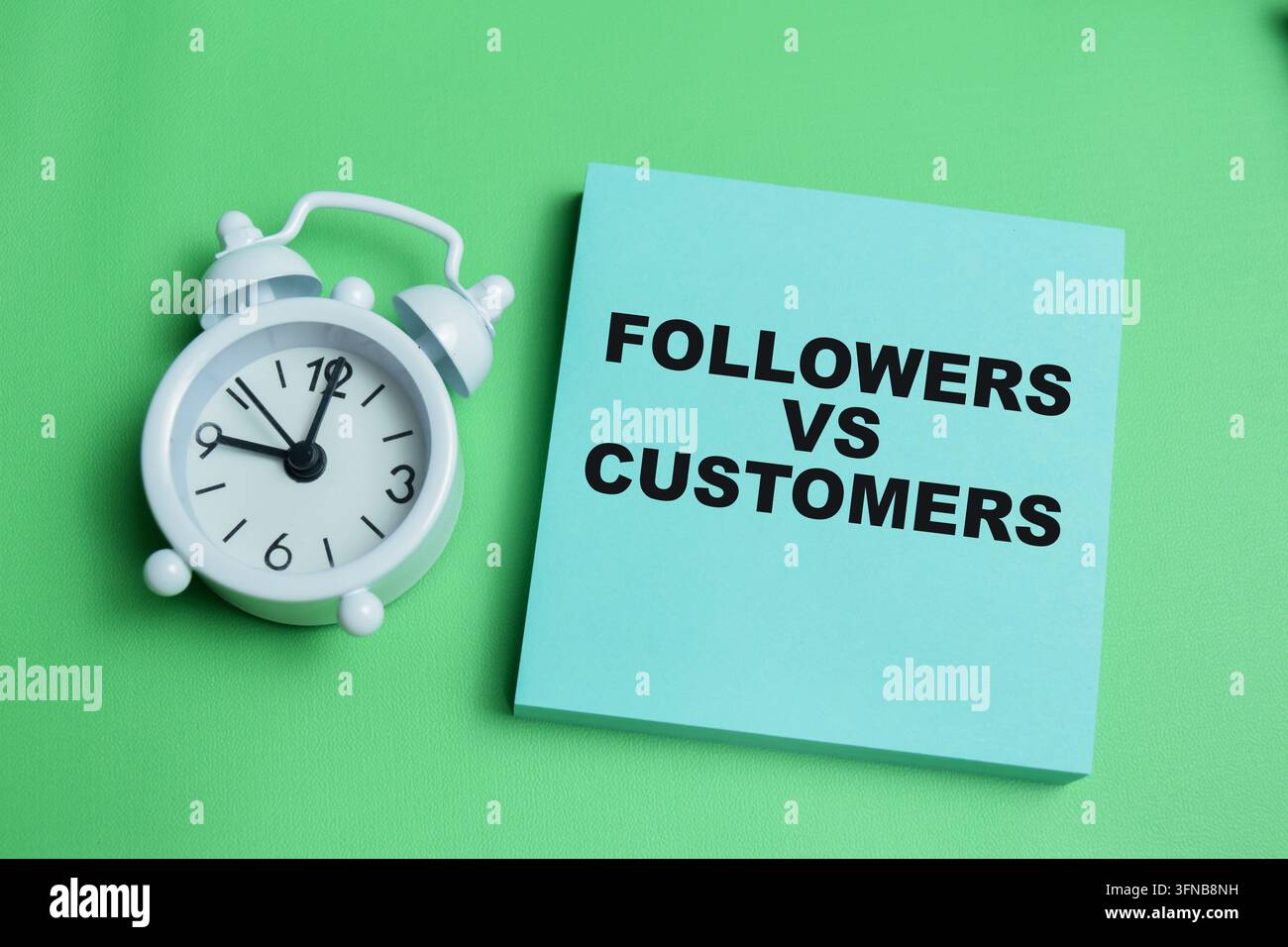 Concetto di follower vs clienti scritto su post-it isolati su un tavolo. Foto Stock