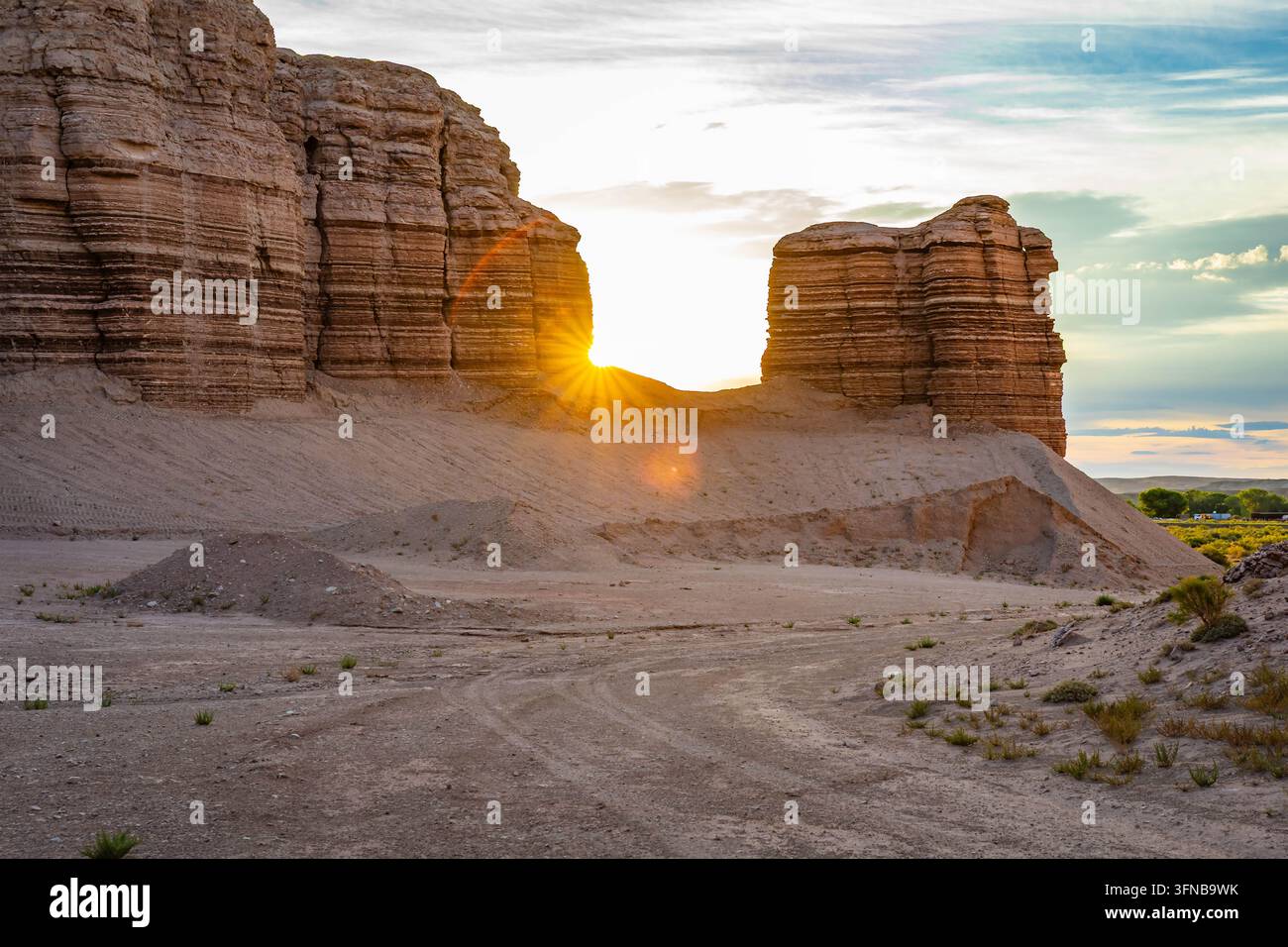 La luce del mattino irrompe tra le formazioni stratificate delle Badlands lungo una remota strada sterrata del deserto vicino a Hanksville, Utah Foto Stock