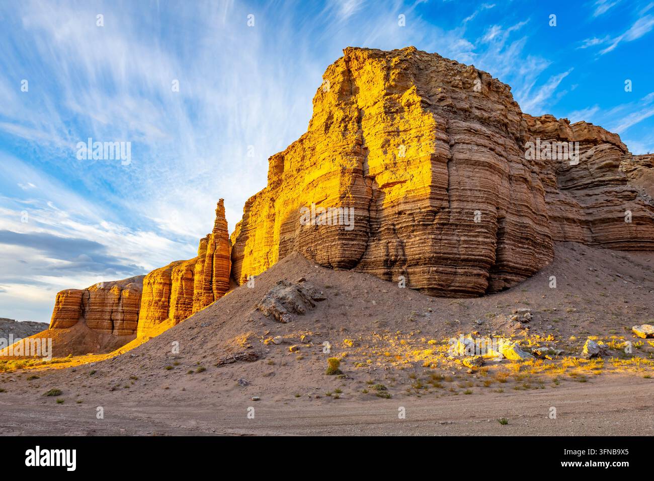 La luce del mattino irrompe tra le formazioni stratificate delle Badlands lungo una remota strada sterrata del deserto vicino a Hanksville, Utah Foto Stock