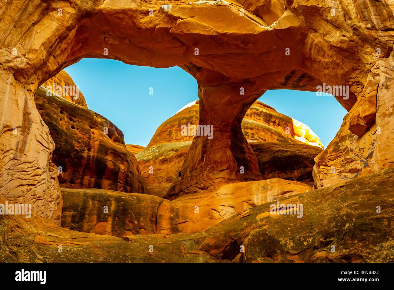Le due aperture in arenaria dell'Arco del Teschio incorniciano il cielo blu chiaro nel labirinto di Fiery Furnace nel Parco Nazionale degli Arches a Moab, Utah Foto Stock