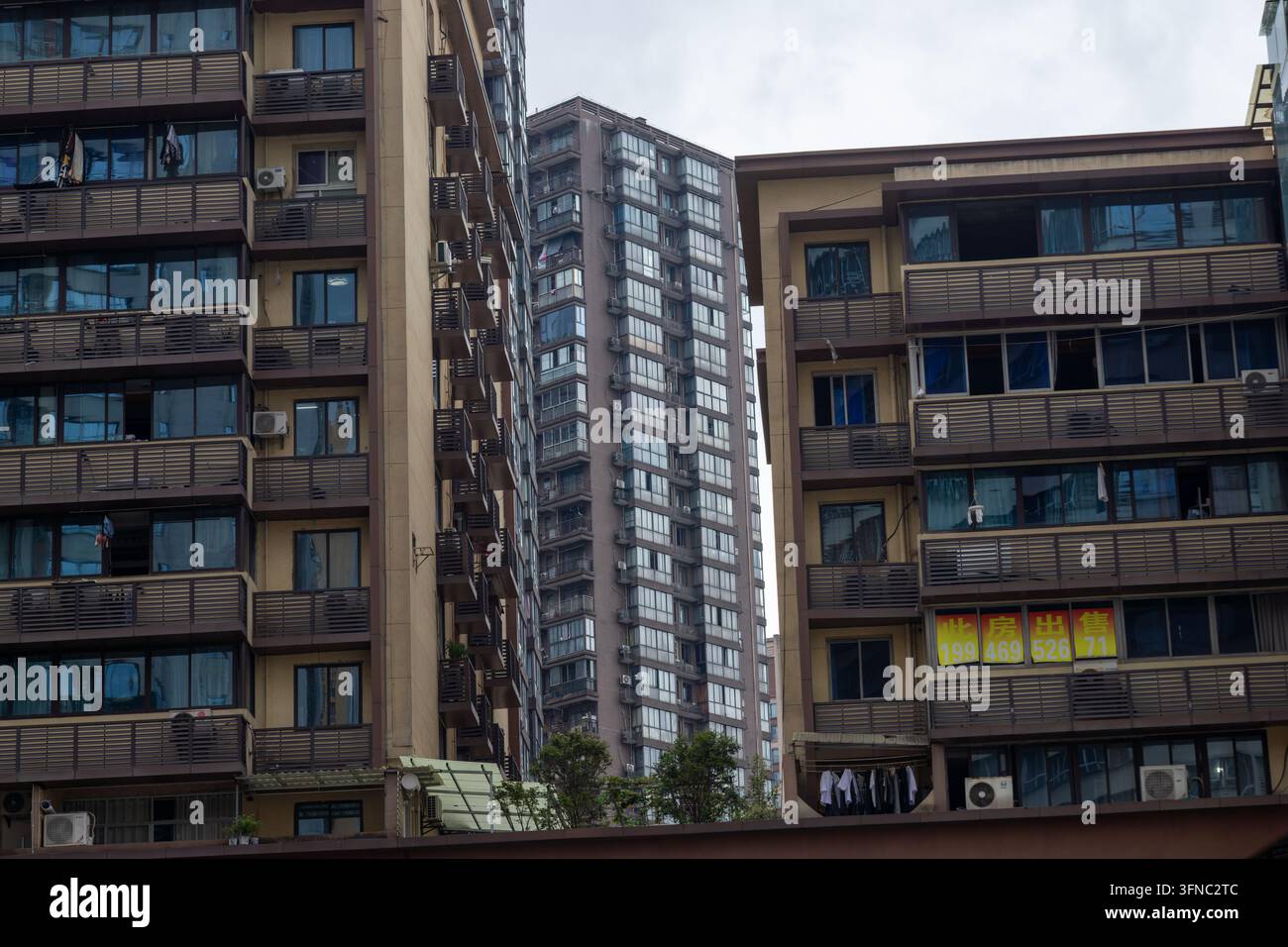 Edifici residenziali ad alta altezza con numerosi balconi e finestre in un ambiente urbano denso Foto Stock