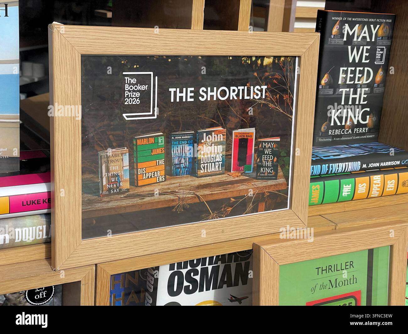 La shortlist del Booker Prize 2026, esposizione nella vetrina di una libreria, con immagini dei libri selezionati all'interno di una cornice fotografica in legno, Regno Unito - Immagine stock catturata con smartphone
