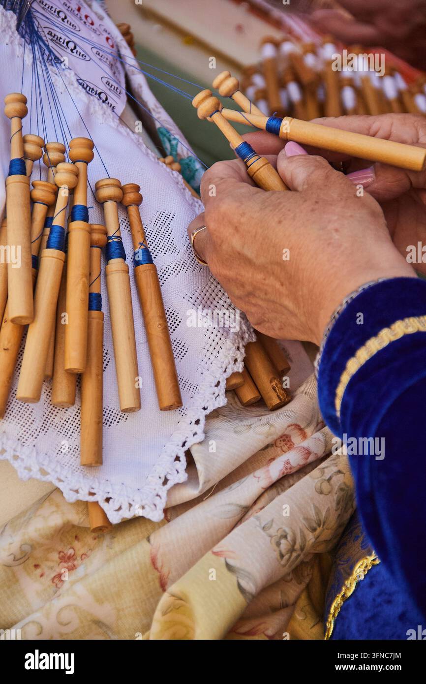 Mani che lavorano bobine di legno per la produzione tradizionale di pizzo al festival delle Capitulaciones de Santa Fe a Santa Fe, Spagna. Foto Stock