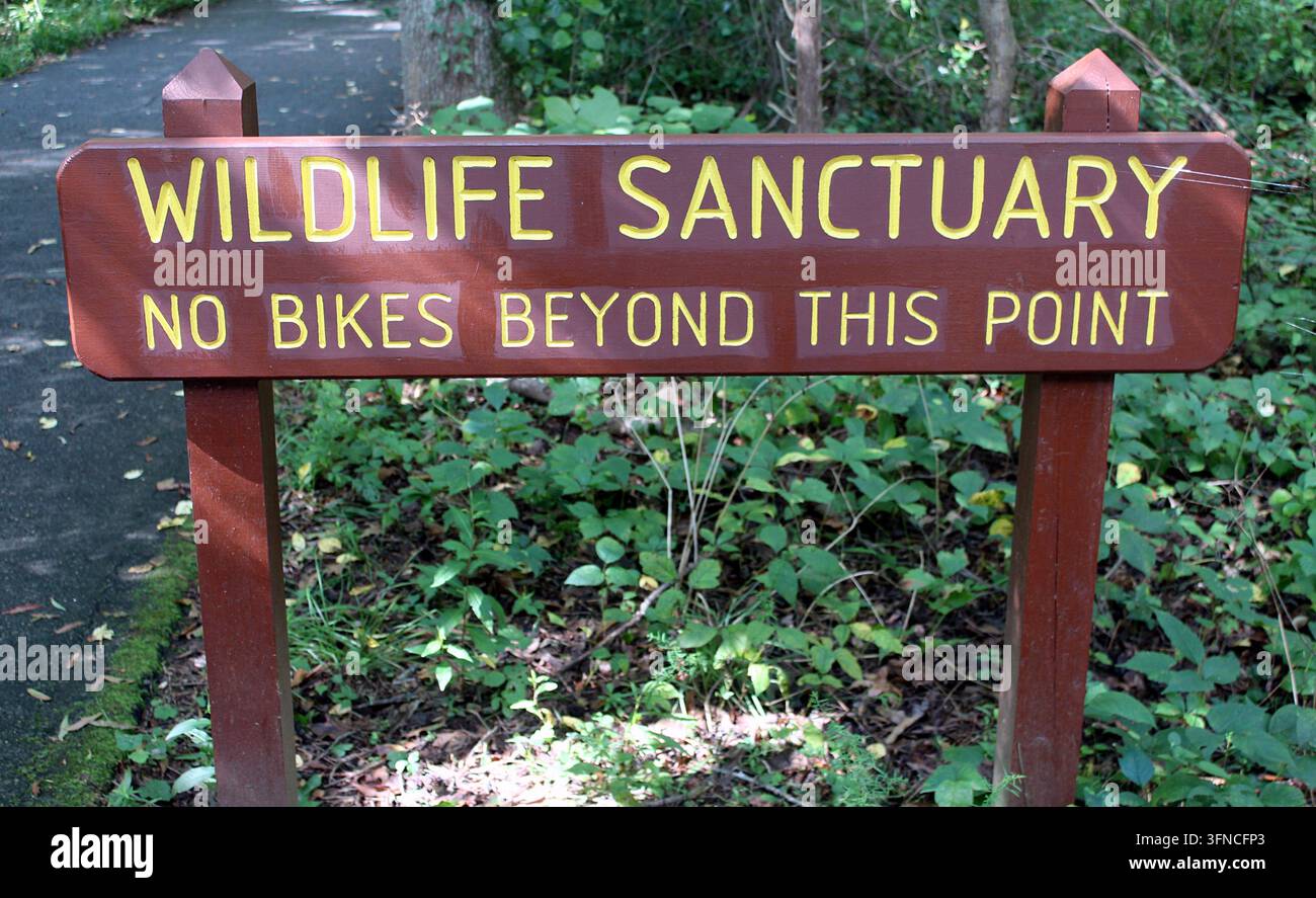 Segnale in legno del sentiero con la scritta Santuario della fauna selvatica divieto di biciclette oltre questo punto al Huntley Meadows Park di Alexandria, Virginia. Foto Stock