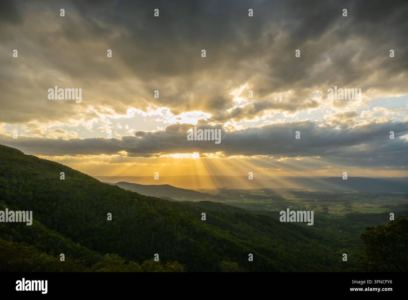 I raggi del sole esplodono dietro uno spesso strato di nuvole al tramonto sul Parco Nazionale di Shenandoah Foto Stock