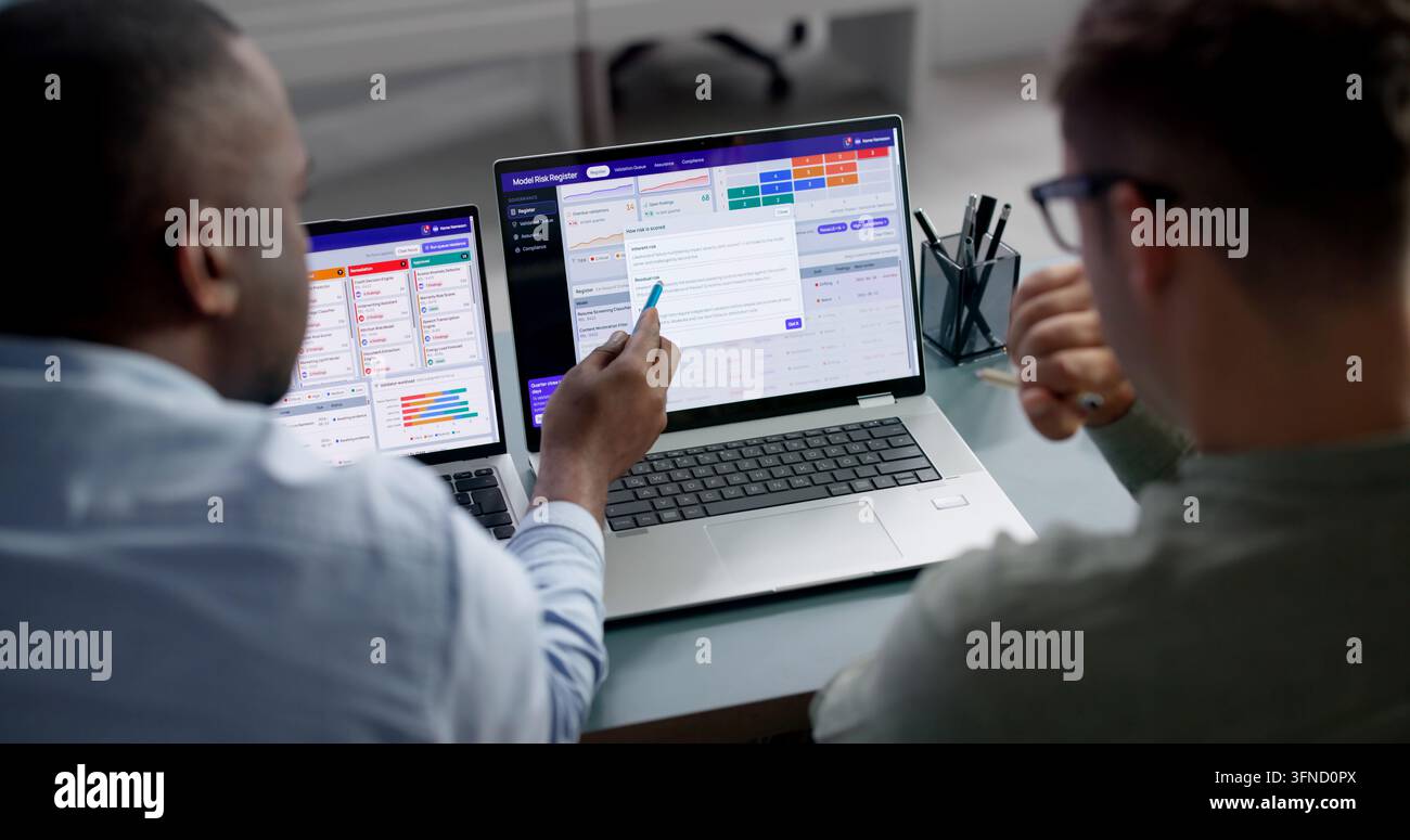 Analista dei dati esamina il rischio di un modello di IA su un laptop per il controllo della conformità. Foto Stock