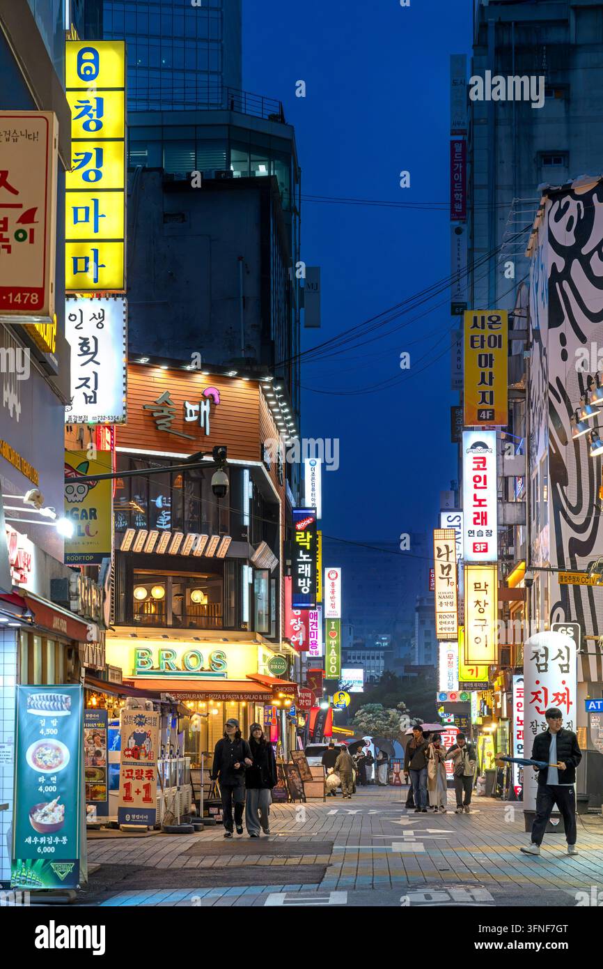 Insegne al neon di ristoranti e negozi nella via dello shopping di Gwancheol-dong di notte, distretto di Jongno nella capitale Seoul, Corea del Sud Foto Stock