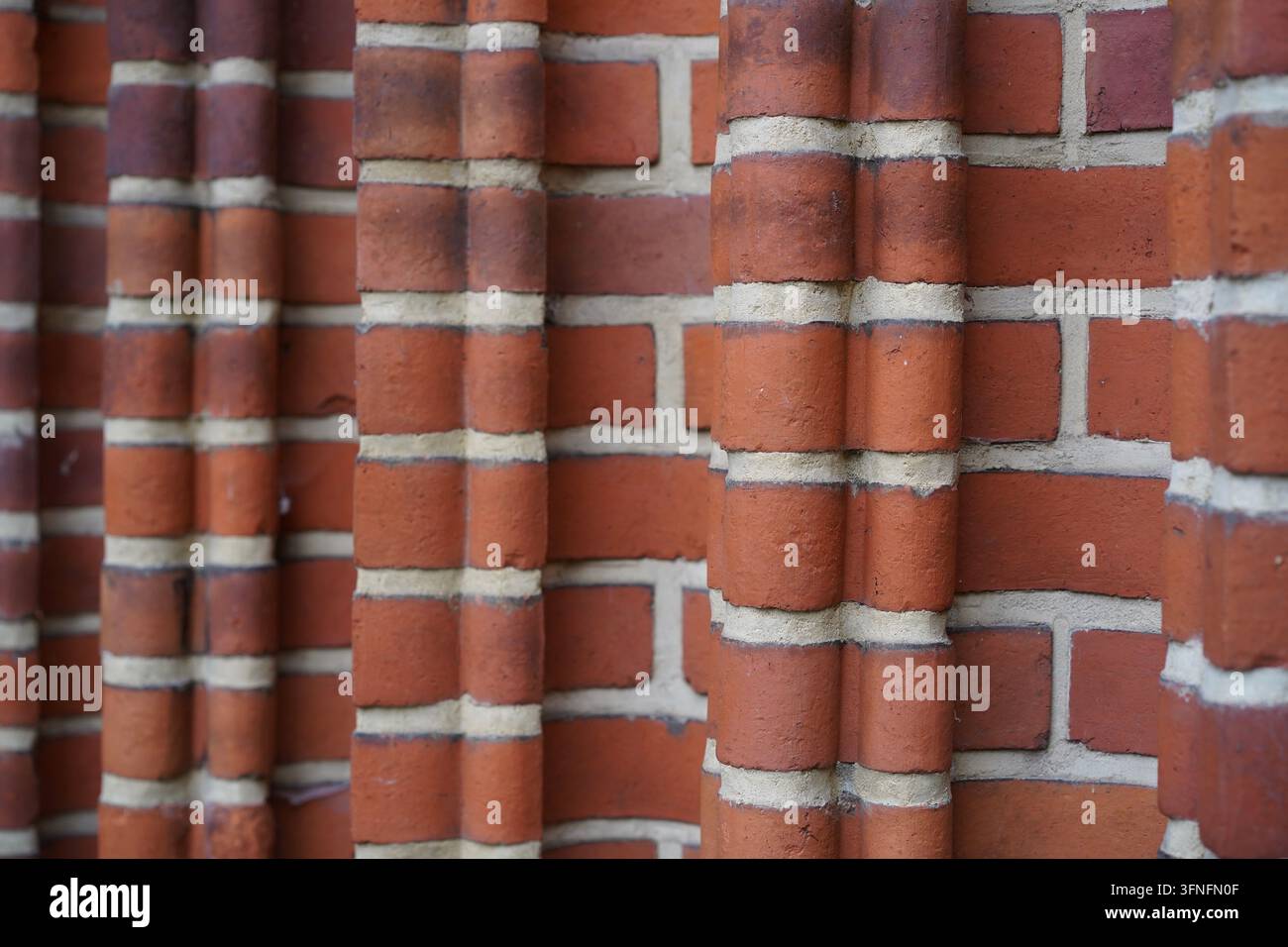 Textura e motivo astratti di un muro storico in mattoni rossi con colonne strutturate e malta chiara nel villaggio di Pankow a Berlino, Germania. Foto Stock