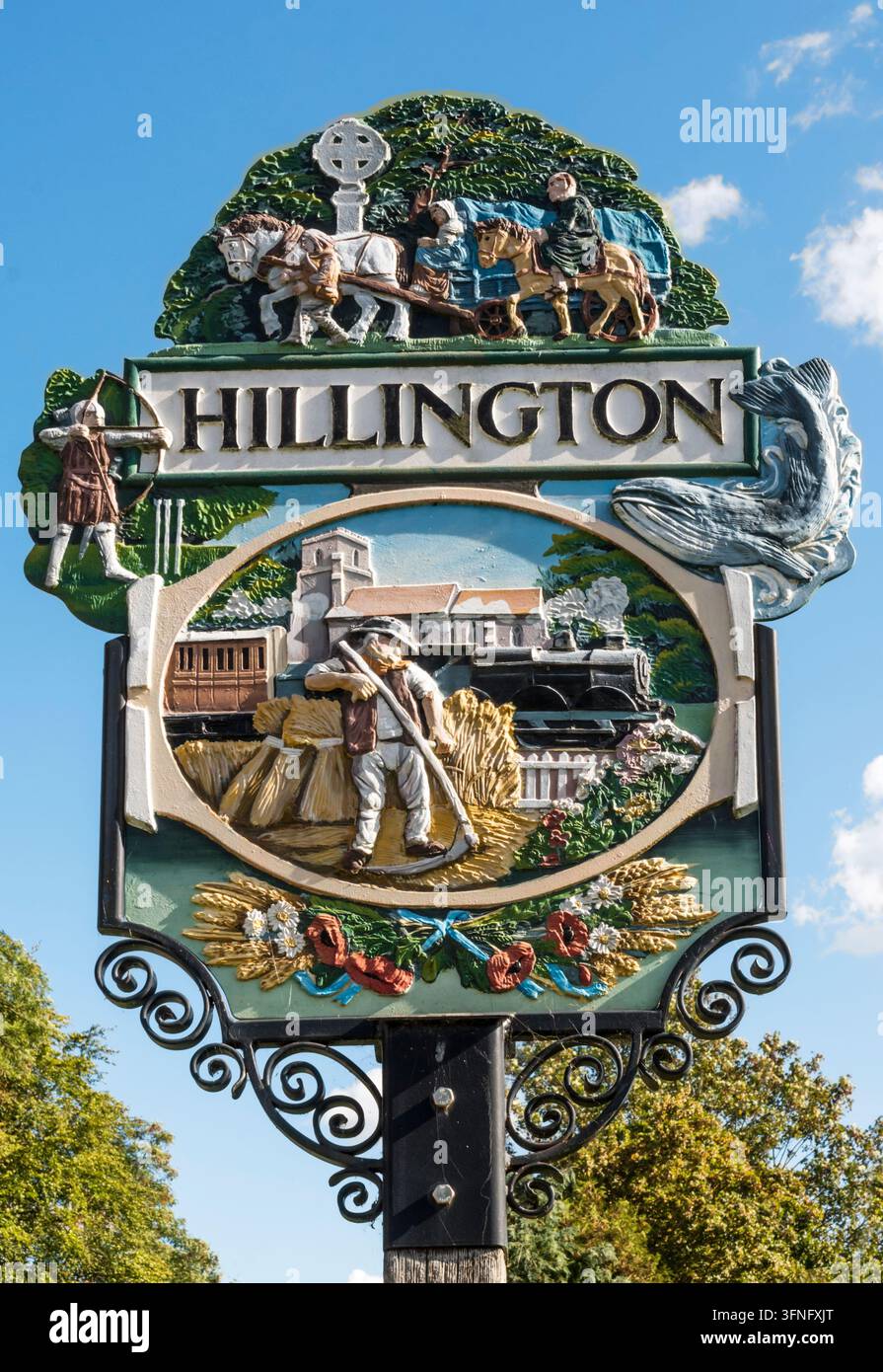 Il cartello della parte occidentale di Hillington include pellegrini in viaggio verso Walsingham e una balena blu – le balene venivano trasportate via nave da The Wash lungo il fiume Babingley. Foto Stock