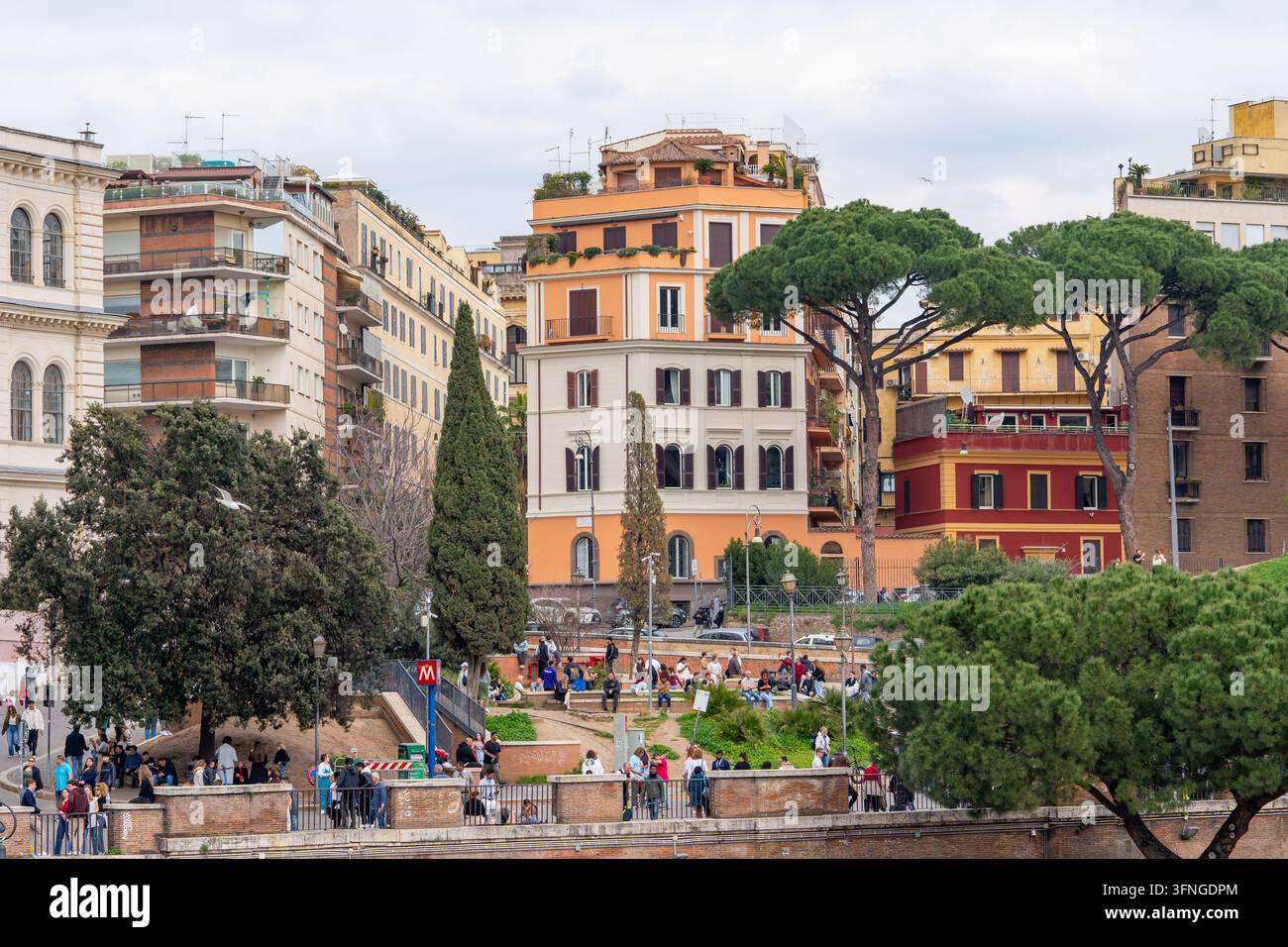 Roma, Italia - 09 marzo 2025: Una scena vivace a Roma con edifici storici, alberi rigogliosi e pedoni che passeggiano lungo una promenade scenografica Foto Stock