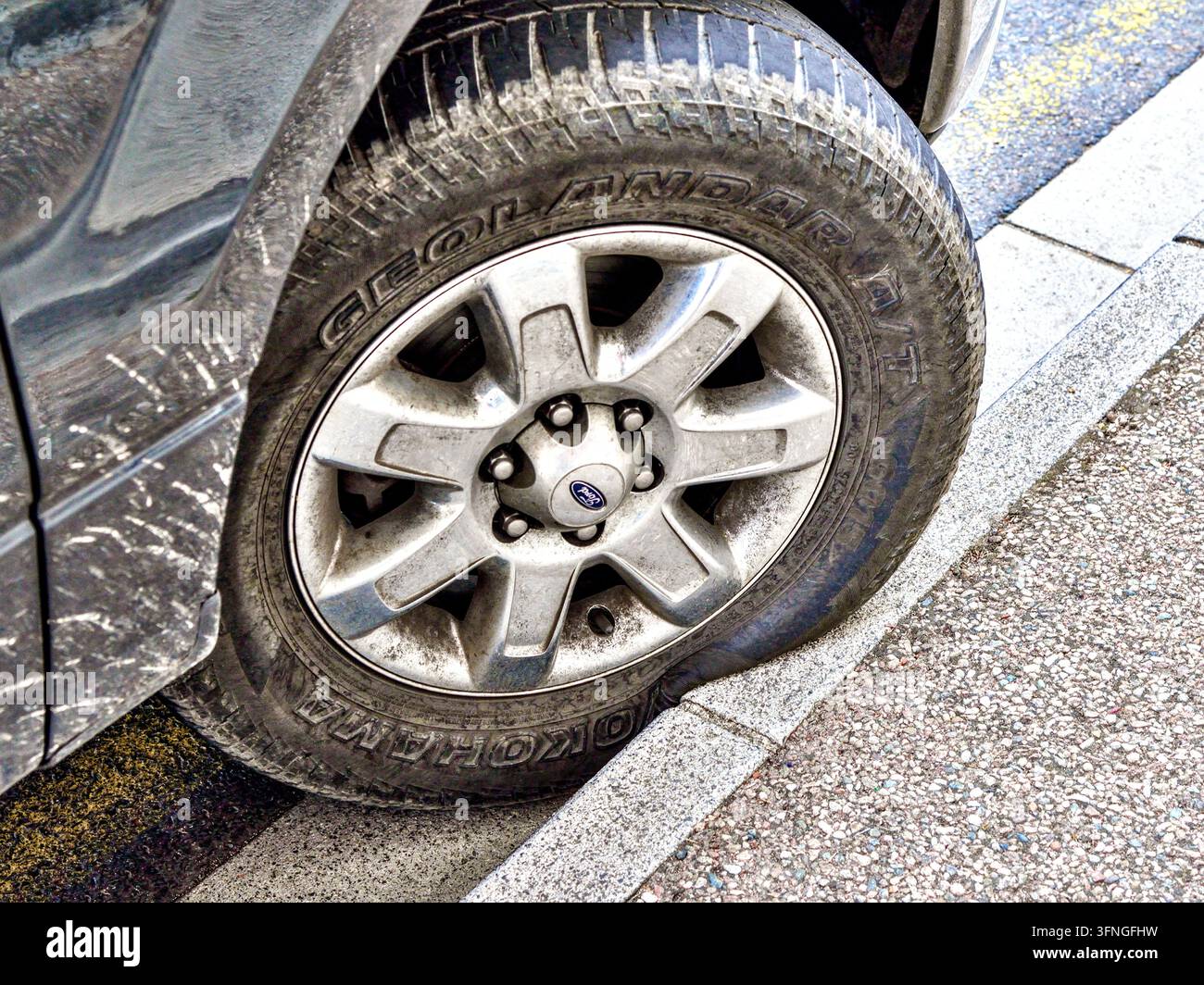 SUV Ford Bronco parcheggiato male con pneumatico Yokohama Geolandar che sporge a causa del contatto con il marciapiede – Francia centrale. Foto Stock